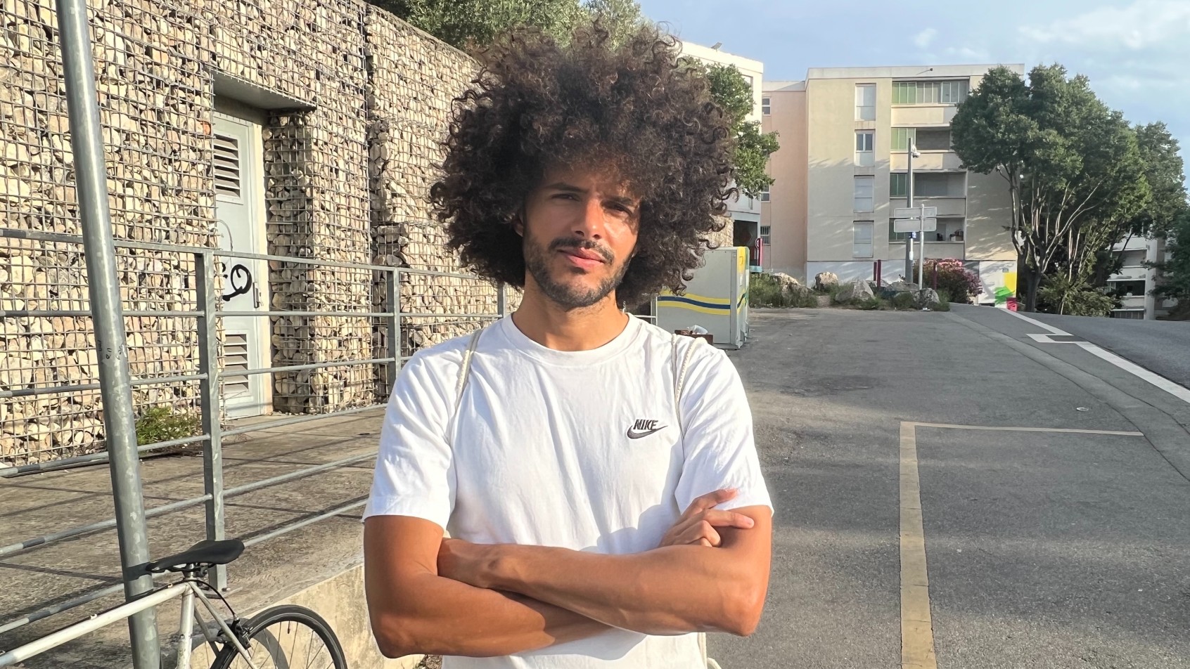 Yassine Amini, a 30-year-old activist and teacher, in the eastern Marseille housing estate of Air-Bel, on 7 July 2023 (MEE/Frank Andrews)