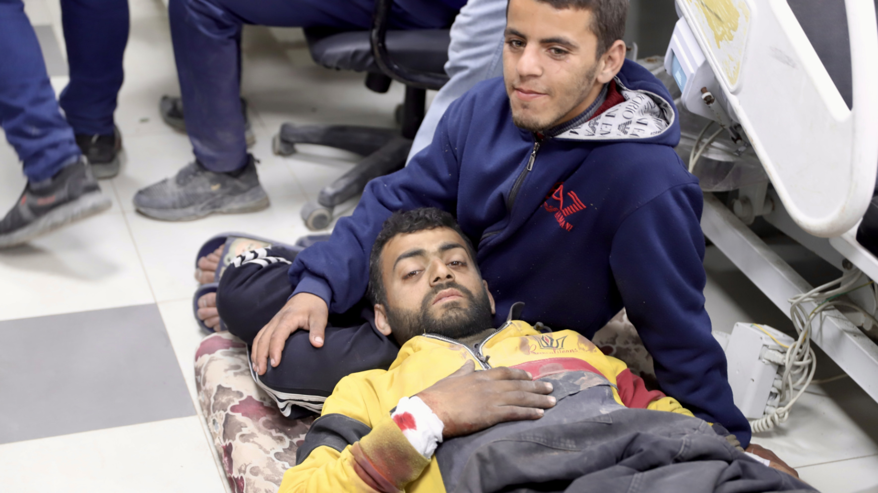 A wounded man rests on a mattress on the floor of al-Shifa Hospital following the Israeli attack on Gazans waiting for aid (Mohammed al-Hajjar/MEE).