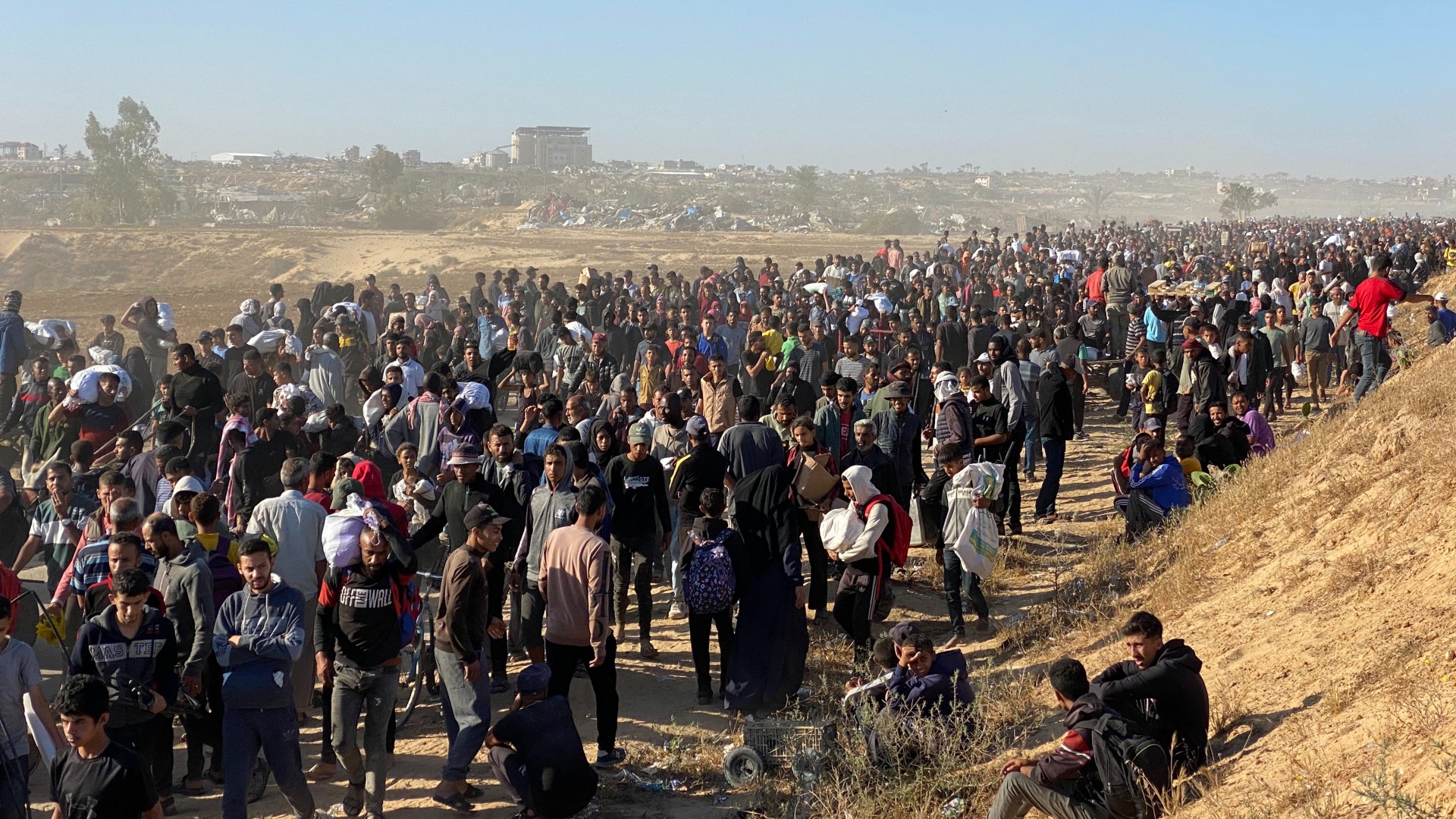 Displaced Palestinians carrying bags of relief supplies return from aid distribution centres in Rafah to their tents in the southern Gaza Strip on May 29, 2025. The humanitarian situation in Gaza, where aid has finally begun to trickle in after a two-month blockade, is dire following 18 months of devastating war between Israel and Palestinian Hamas movement. Food security experts say starvation is looming for one in five people. (AFP)