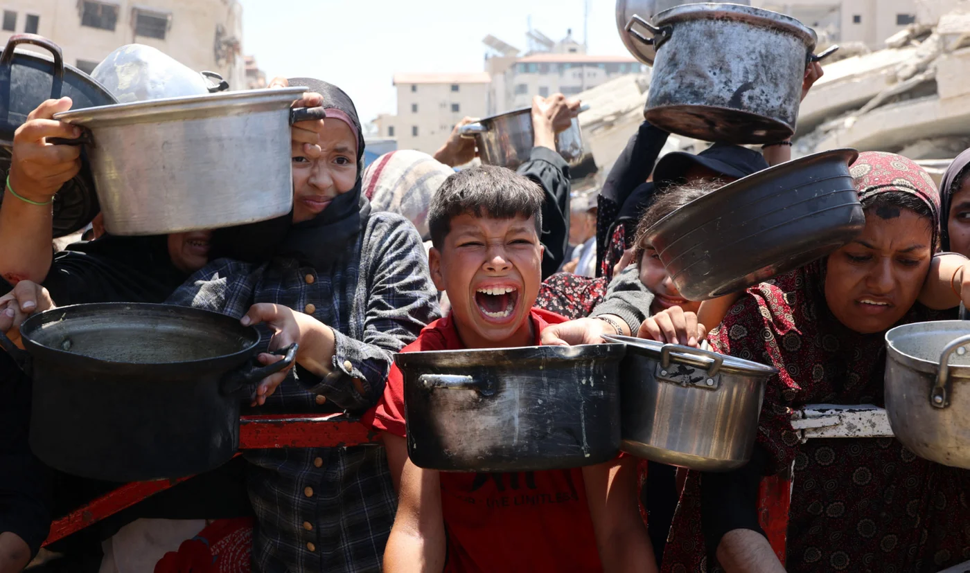 Palestinians gather at a lentil soup distribution point in Gaza City, in the northern Gaza Strip, on 27 July 2025 (AFP)