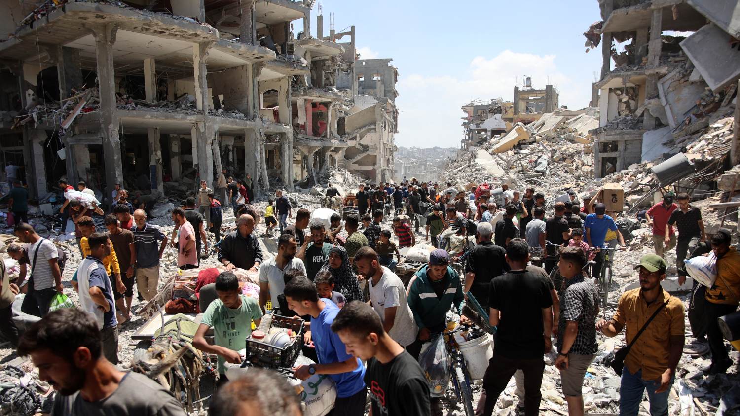 Palestinians carry some salvaged belongings as they leave the Jabalia refugee camp in northern Gaza after they returned briefly to check on their homes on 30 May 2024