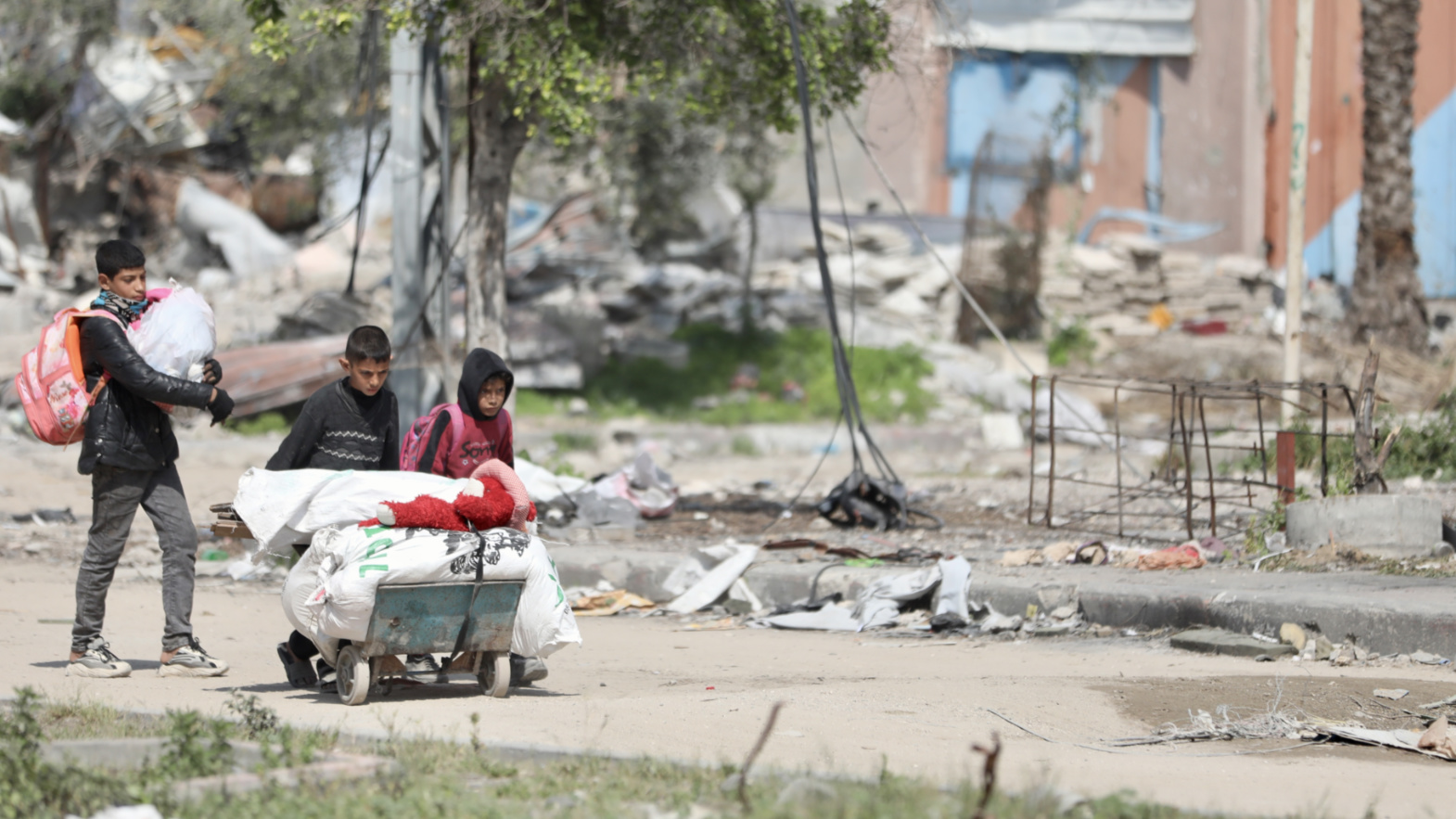 Children carrying bags in northern Gaza (Mohammed al-Hajjar/MEE).