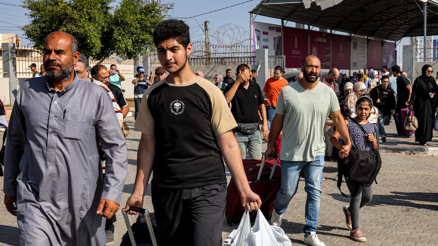 People walk through a gate to enter the Rafah border crossing to Egypt in the southern Gaza Strip on 1 November 2023.