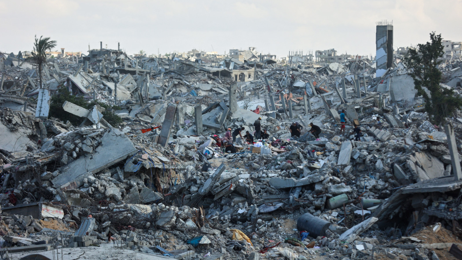 Palestinians search the rubble of buildings amid widespread destruction cause by Israeli bombardment in Khan Yunis in the southern Gaza Strip, 12 October 2025 (Omar al-Qattaa/AFP)