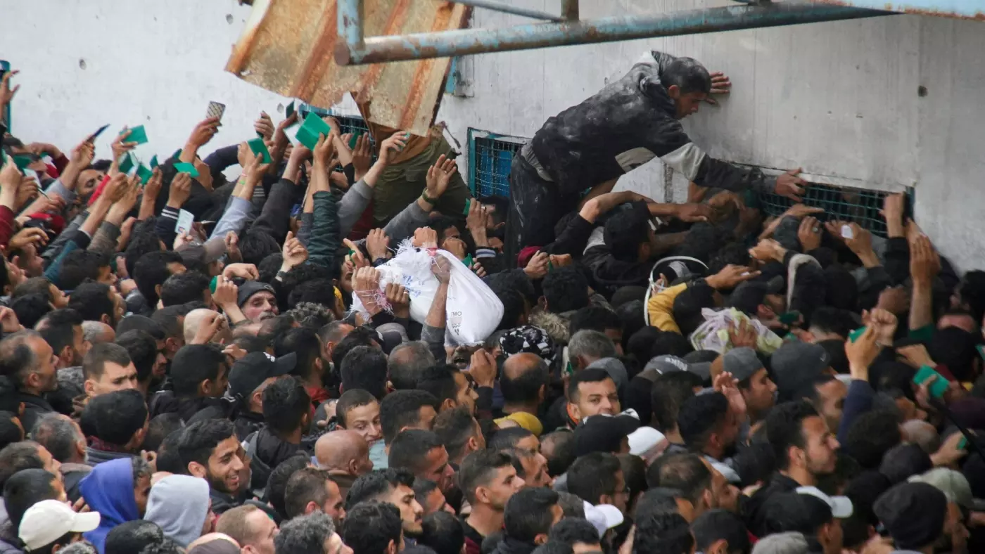 palestinians gather to receive aid