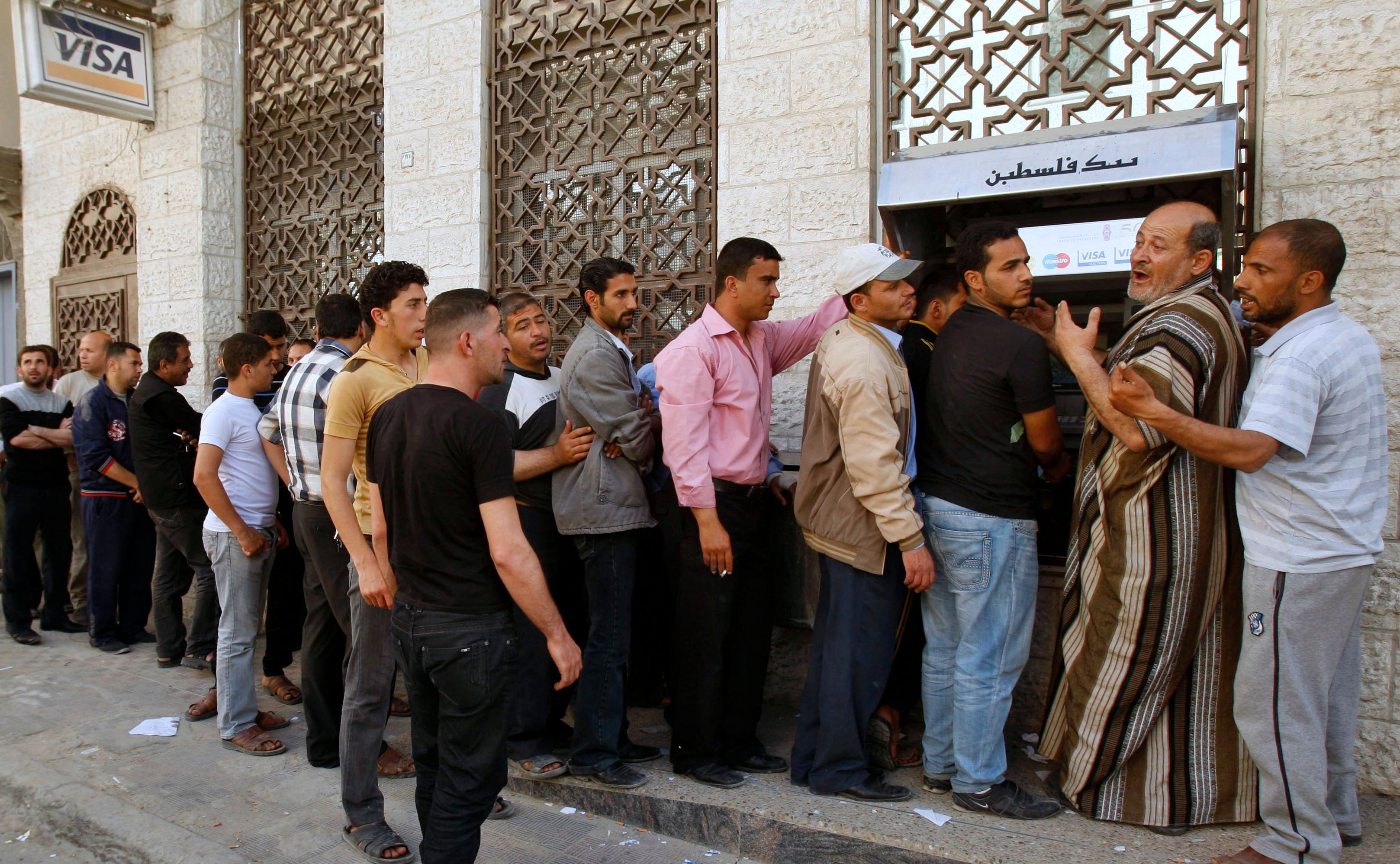 Des employés de l’Autorité palestinienne font la queue pour récupérer leur salaire à un guichet automatique, à Khan Younès (bande de Gaza), en avril&nbsp;2012 (Reuters)