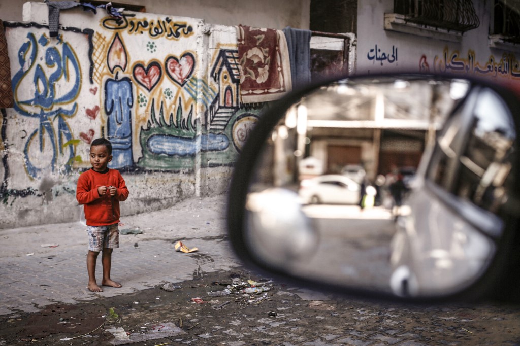 A Palestinian boy stands near his home in al-Shati refugee camp in Gaza on 6 December (AFP)