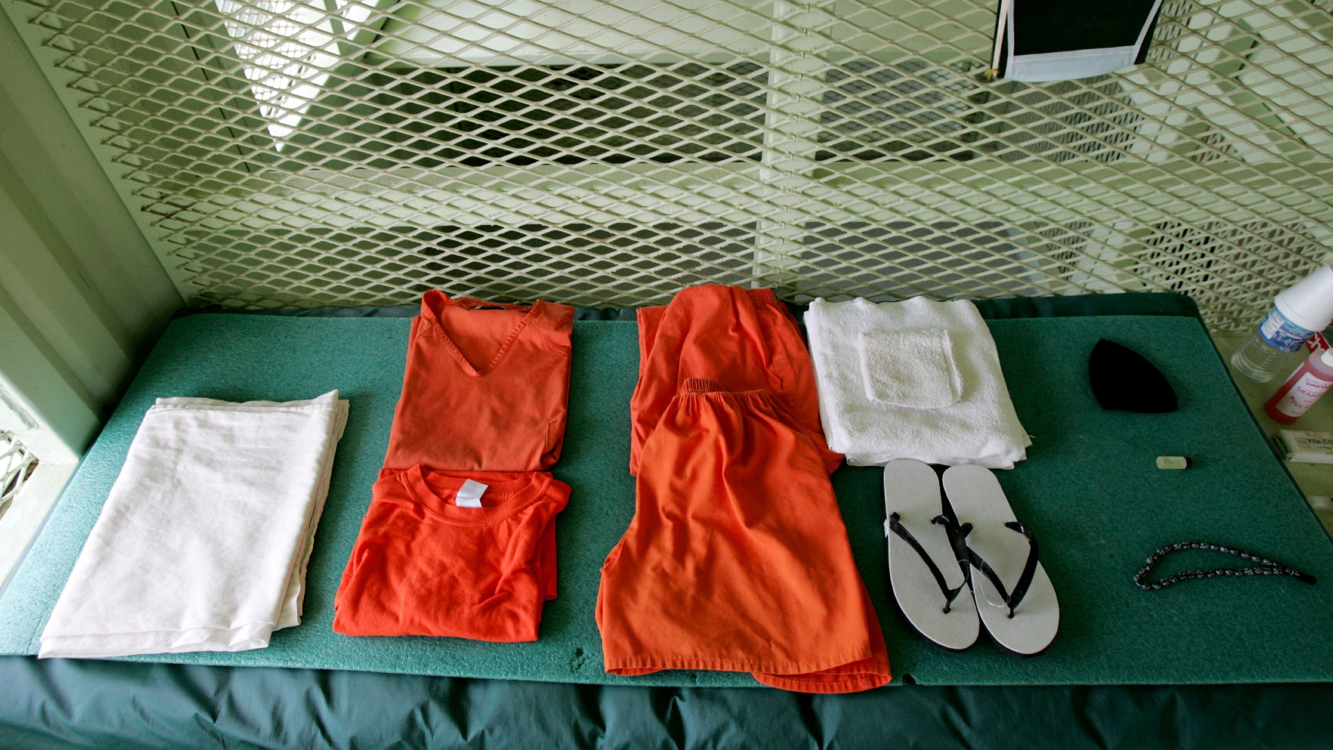 A uniform given to a detainee lies on a bed in a cell at Camp Delta in Guantanamo Bay on 23 August 2004 (Mark Wilson/AFP)