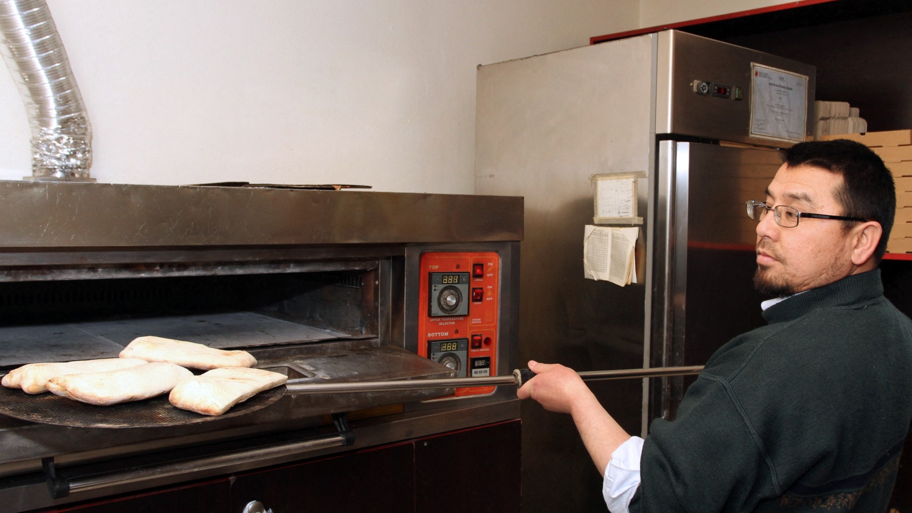 Abu Bakker Qassim, a Chinese Muslim and an ethnic Uighur released from Guantanamo prison and resettled in Albania, makes pizzas in Tirana on 6 January 2012 (Gent Shkullaku/AFP)