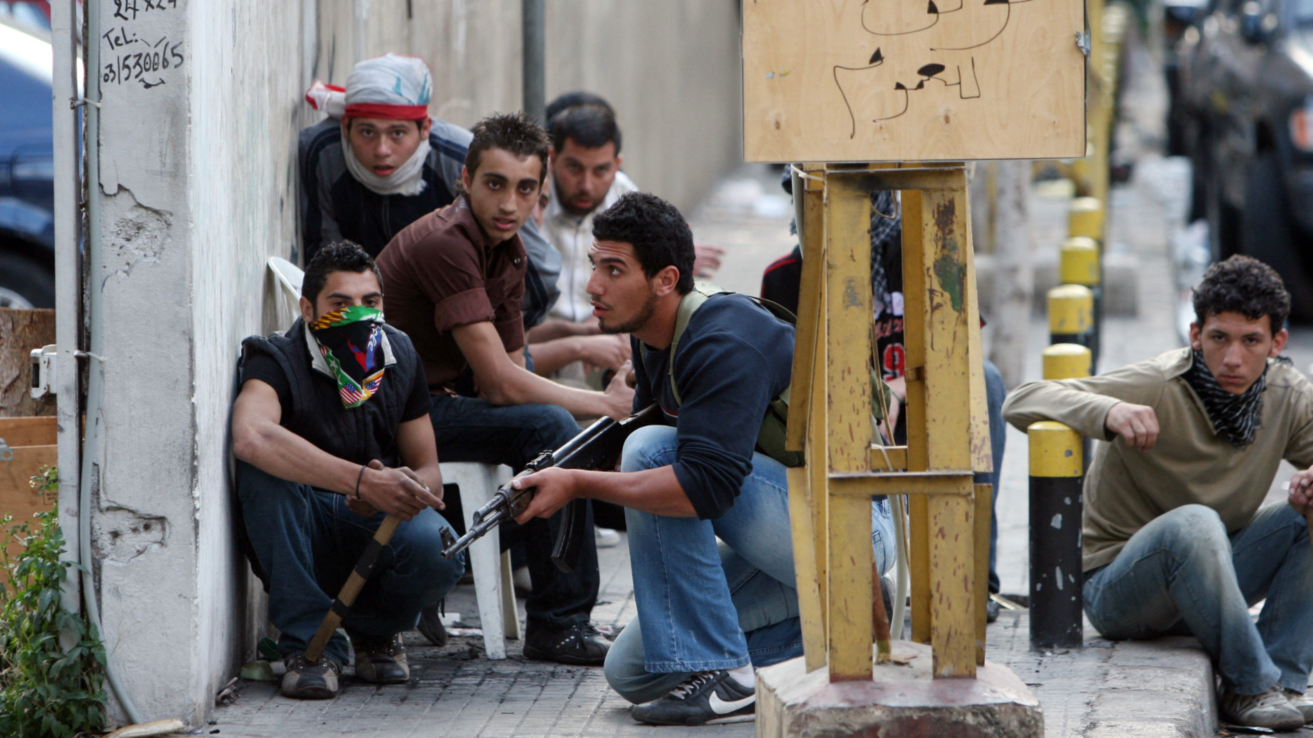 Pro-Hezbollah gunmen take up a position behind a wall during clashes with pro-government supporters in a street in Beirut on 8 May 2008 (AFP)