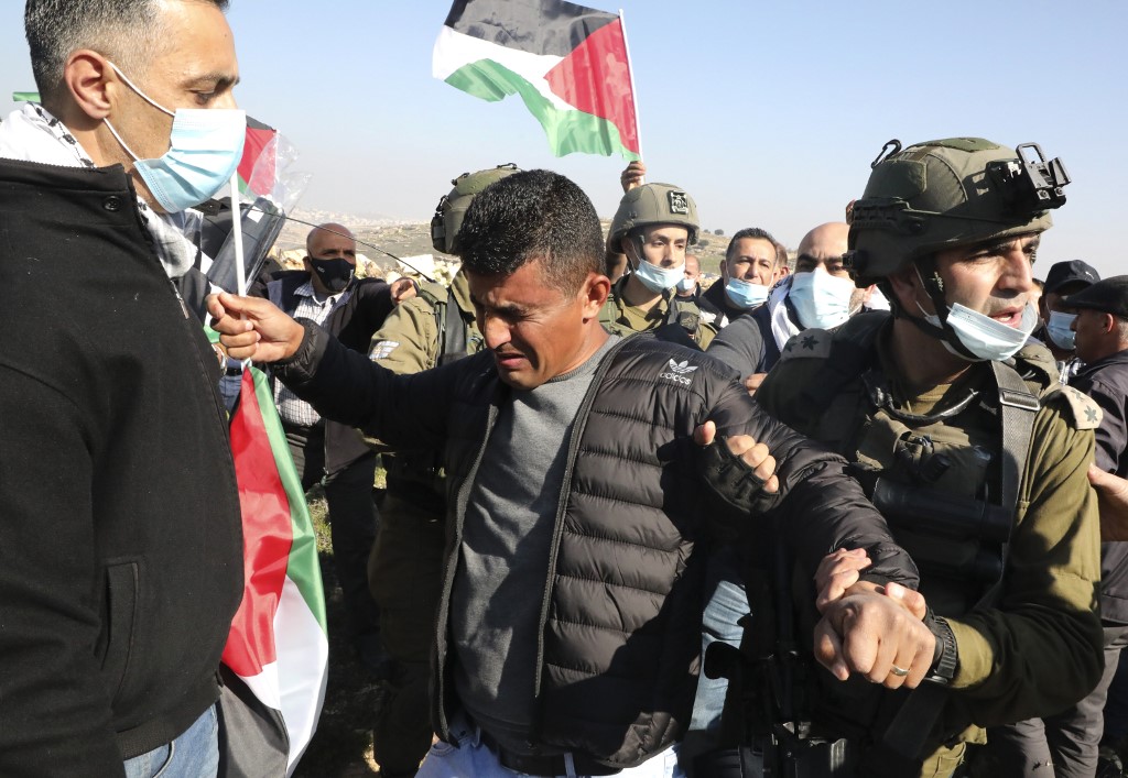 Members of Israel's security forces block Palestinians trying to reach their lands confiscated by Israeli authorities, during a protest in the village of Halhul, north of Hebron in the occupied West Bank, on January 4, 2021. (AFP)