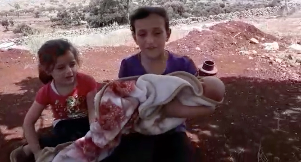 Two of Rabaa al-Shamaa's daughters hold their month-old brother, Nasser (Supplied)