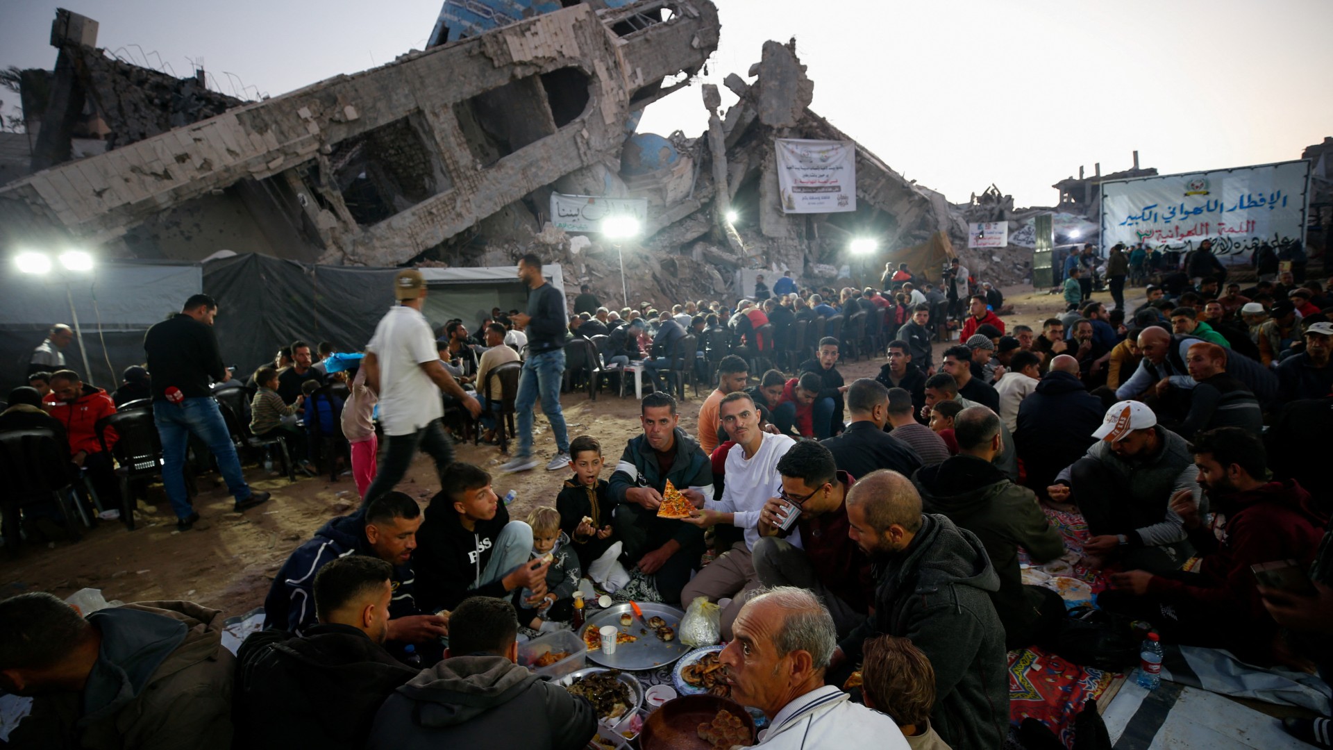 Palestinians break their fast by eating Iftar meals during the holy month of Ramadan, near the rubble of buildings, in the northern Gaza Strip 15 March (Reuters/Mahmoud Issa)