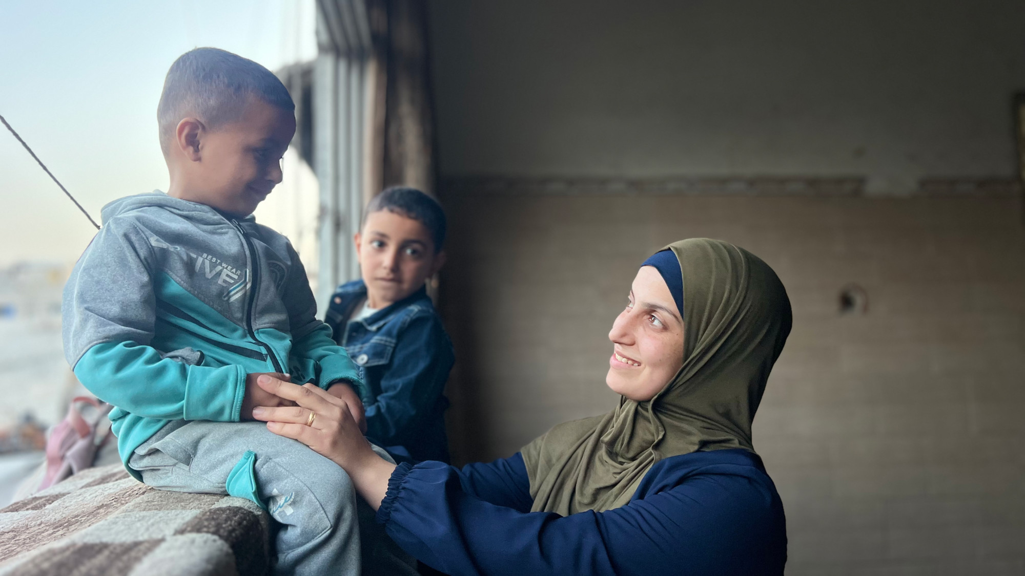 Adam (L) did not initially recognise his mother, Saeda al-Shrafi (R), after her release in January 2024 (MEE/Ahmed Dremly).