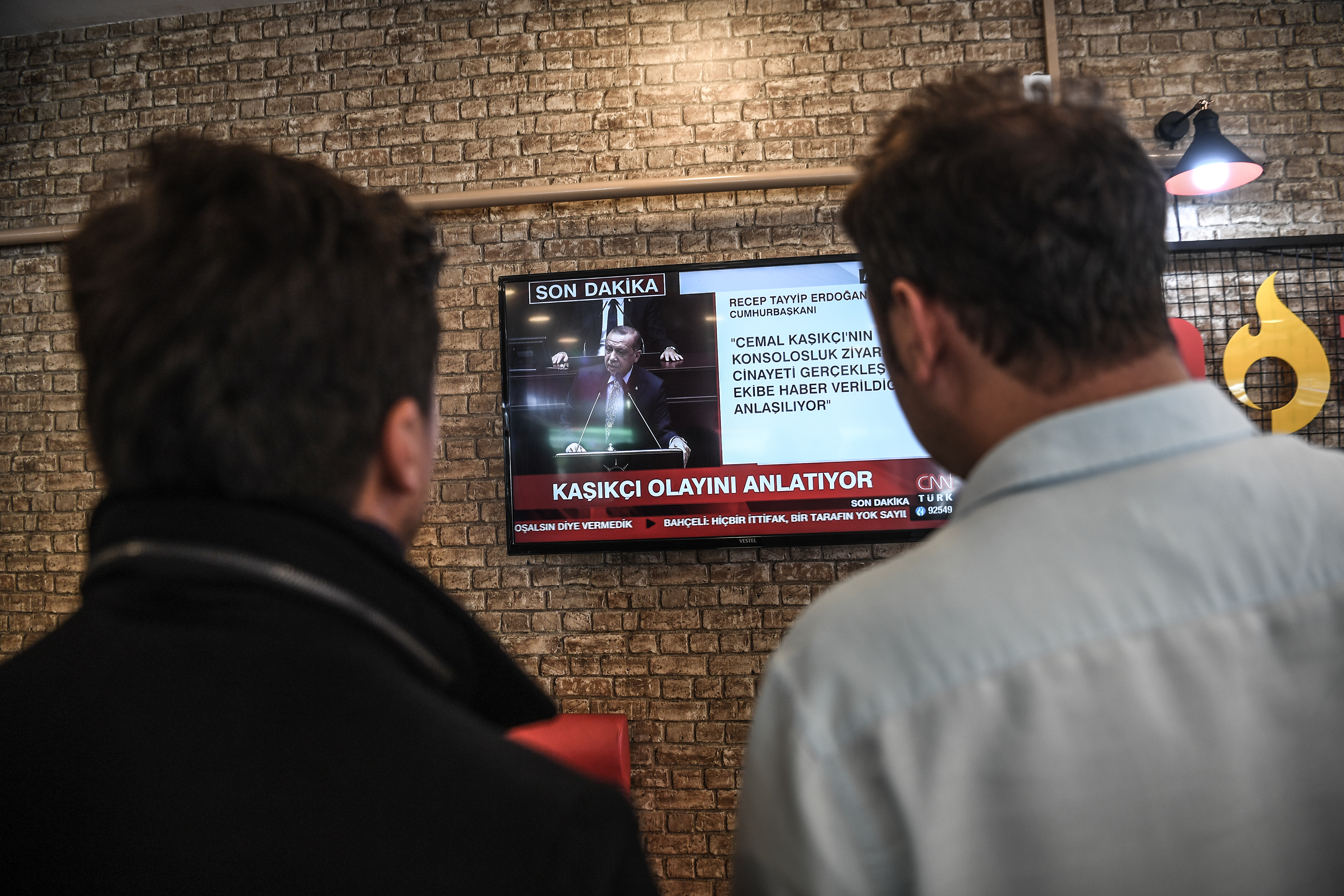 People watch the Turkish president speak at an Istanbul cafe on 23 October (AFP)