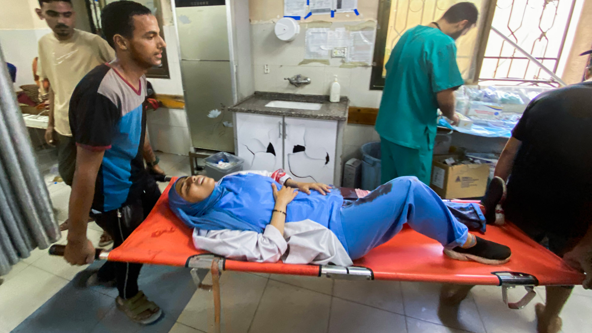 Palestinians transport a medic wounded in Israeli strikes on Nasser hospital in Khan Yunis in the southern Gaza Strip on 25 August 2025 (AFP)
