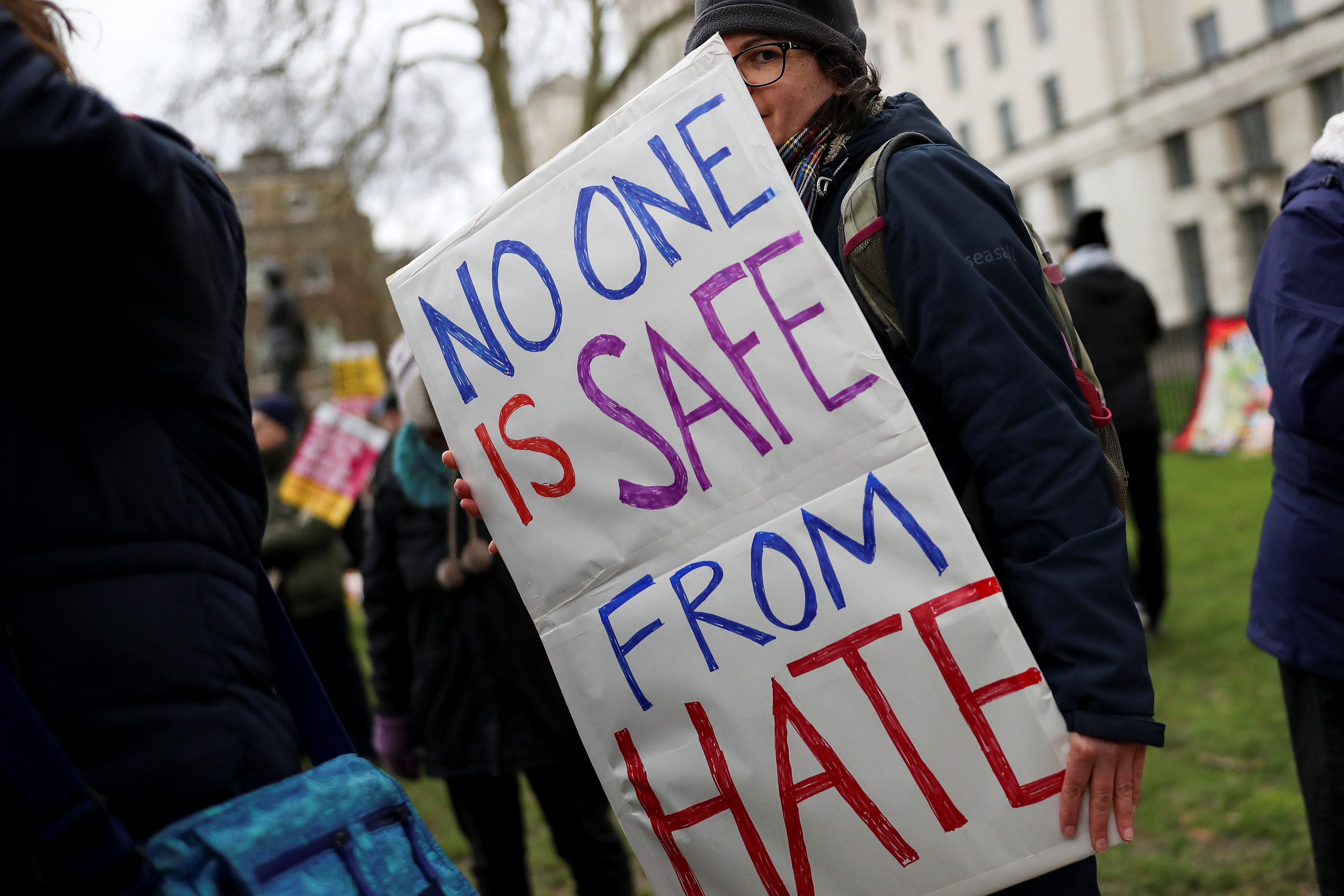 A protester holds a placard as she takes part in an anti-racism march in London, Britain on 16 March (Reuters)