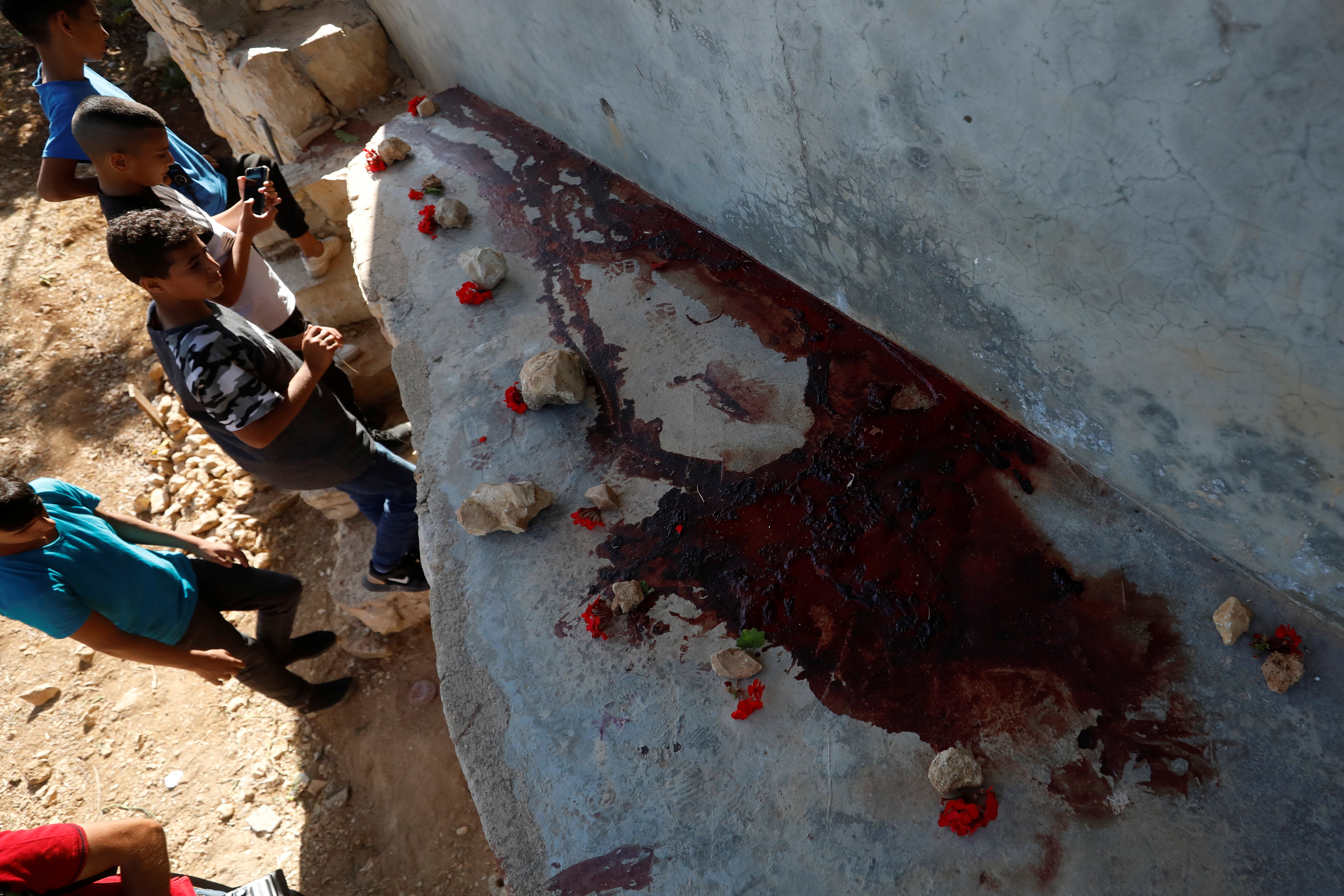 Boys check the scene where three Palestinians were killed by Israeli forces during a raid in Beit Anan in the occupied West Bank (Reuters) 