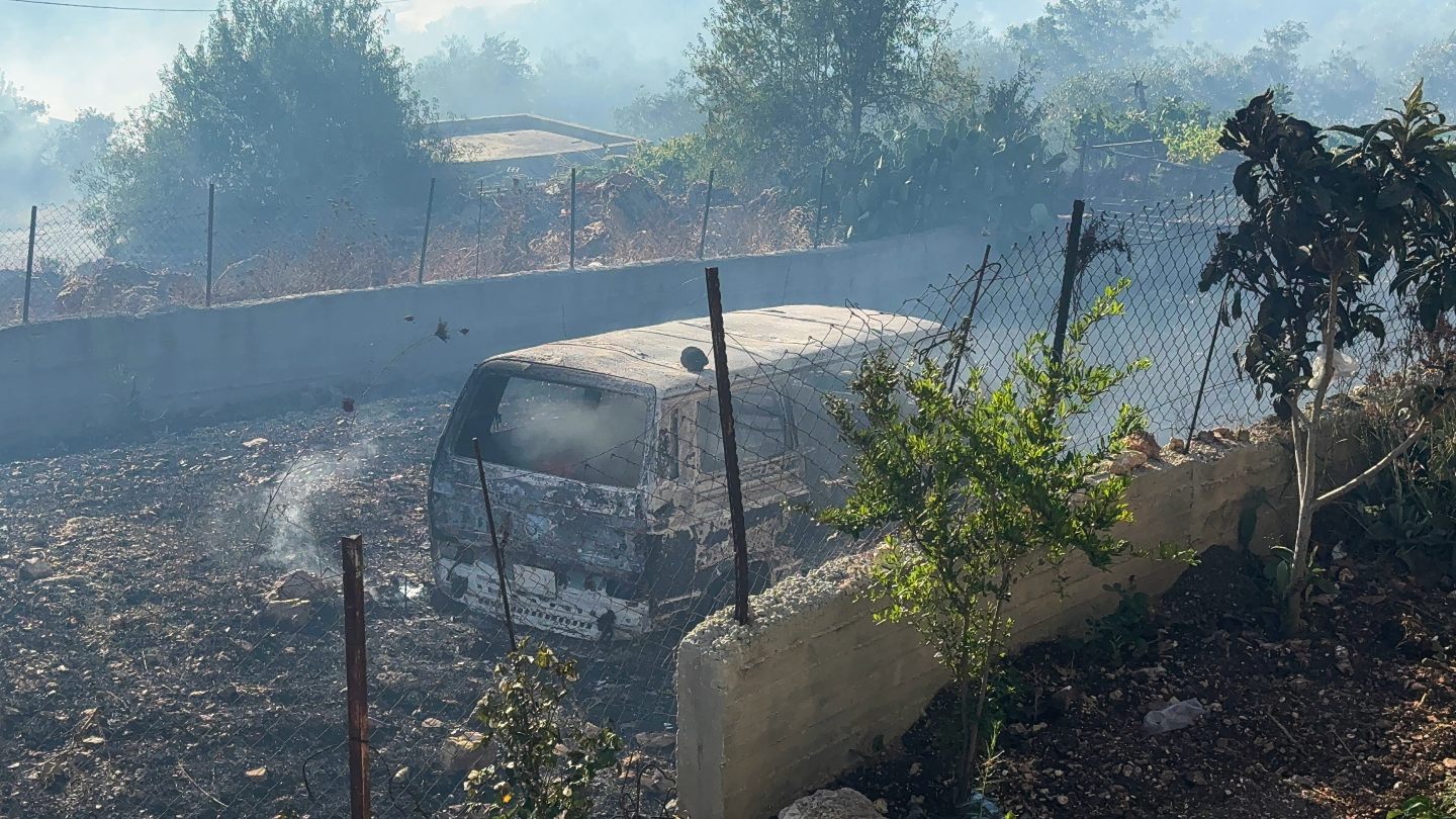 A car burned during an attack by Israeli settlers is seen in the Palestinian village of Sarra, southwest of Nablus in the occupied West Bank (Atiq/Middle East Eye)