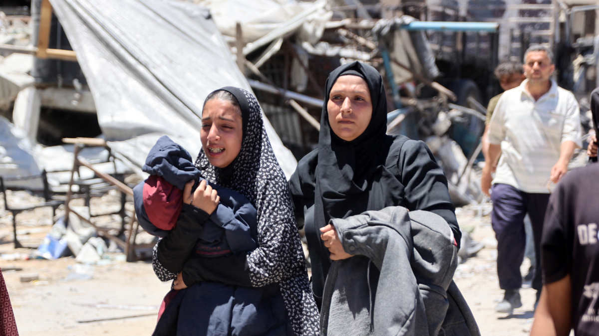 A Palestinian woman reacts as she walks through a devastated street in Jabalia refugee camp in northern Gaza Strip, on 31 May.
