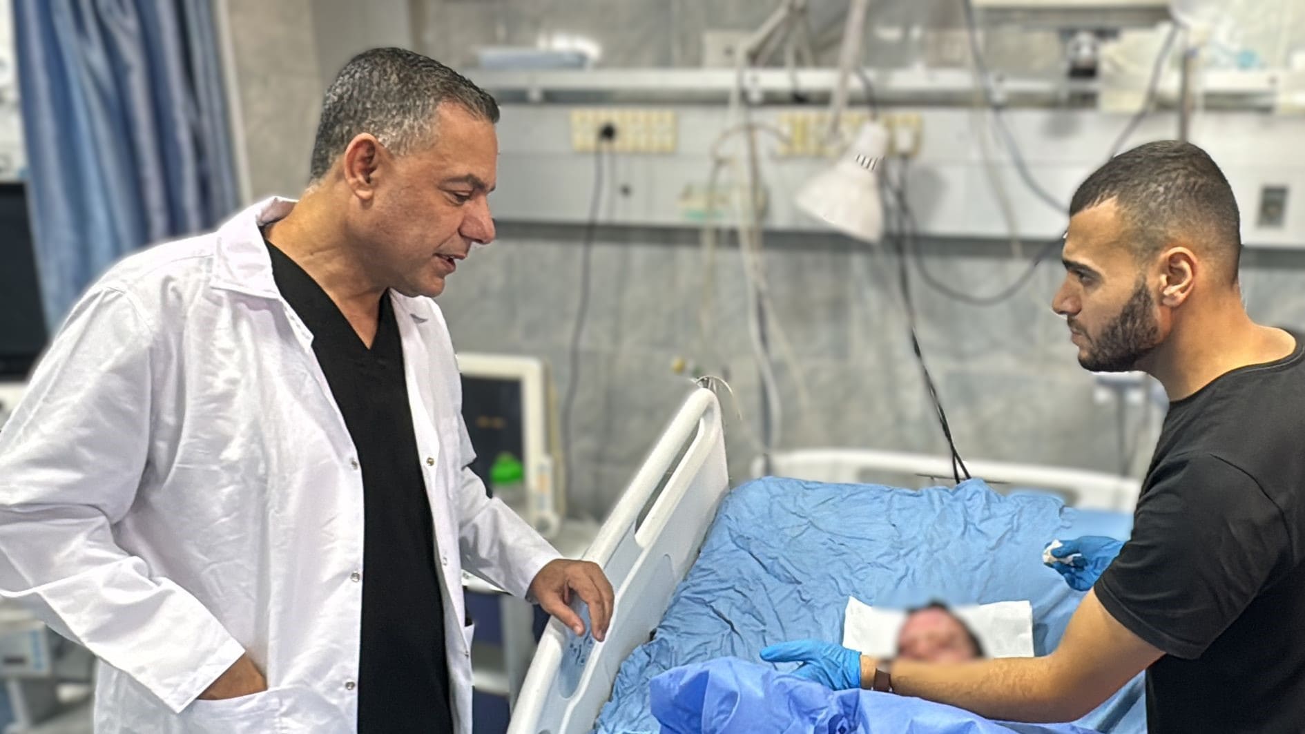 Hussam Abu Safiya, the director of Kamal Adwan Hospital in Beit Lahia, checks on an injured child on 24 October in north Gaza (AFP)