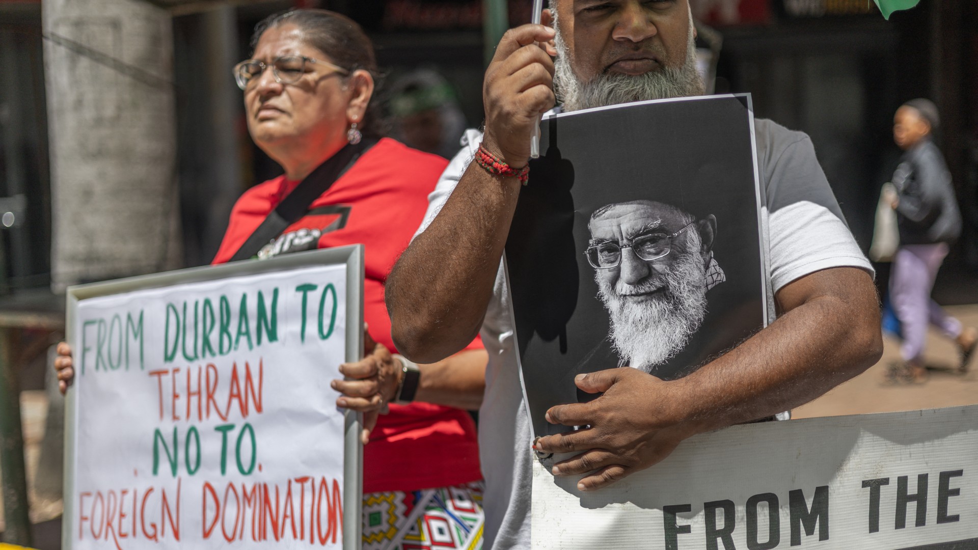 A protester holds a portrait of Iran's late supreme leader Ayatollah Ali Khamenei while gathering during a solidarity protest outside the US Consulate in Durban on 3 March 2026 (Rajesh Jantilal/AFP)