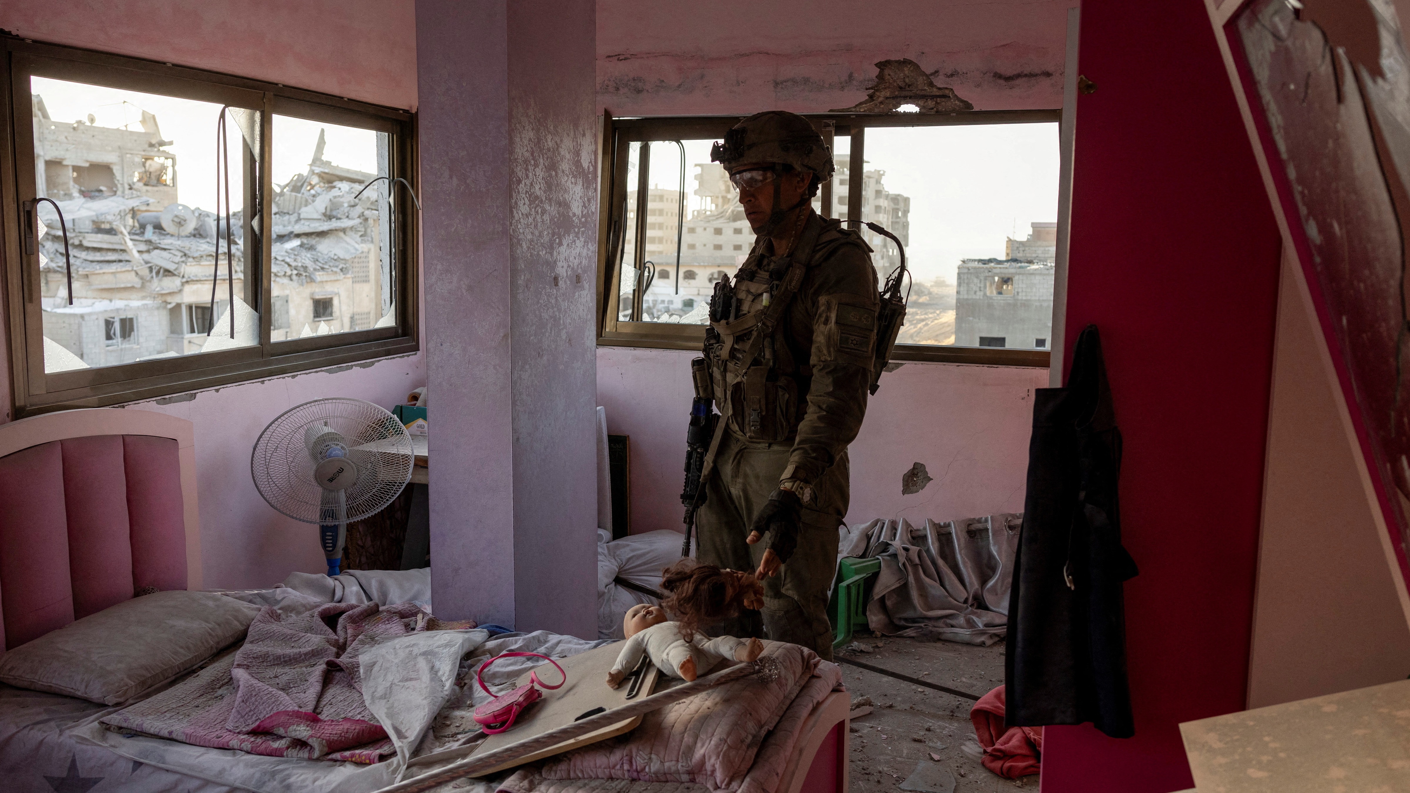 Israeli soldier wades through a damaged building in Gaza after it launched its ground invasion