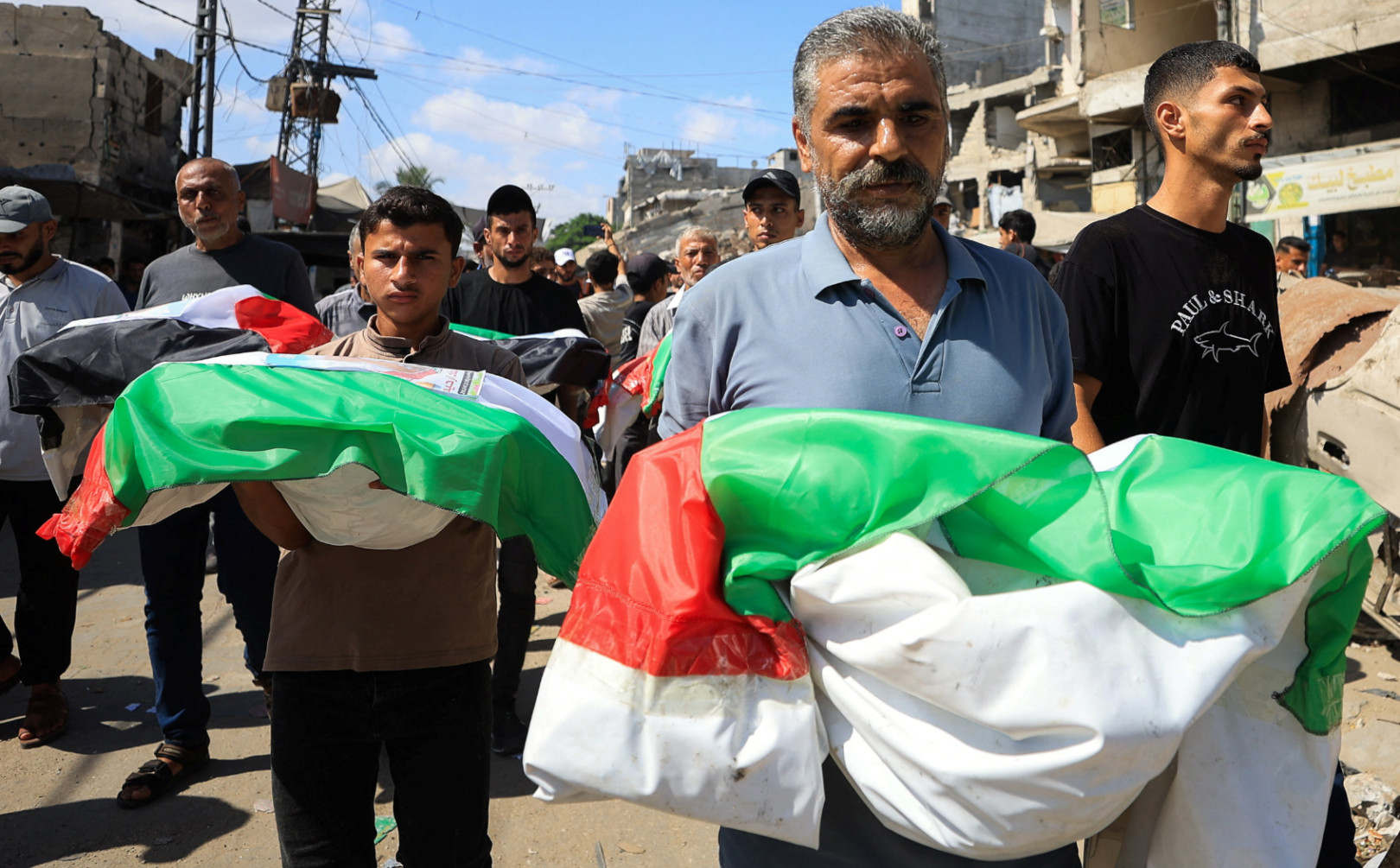 Mourners carry bodies covered in Palestinian flags, on the day of the mass funeral for Palestinians killed in an Israeli strike in 2023 and whose remains were recovered from beneath the rubble in Gaza City, 6 September 2026. (Dawoud Abu Alkas/Reuters) 