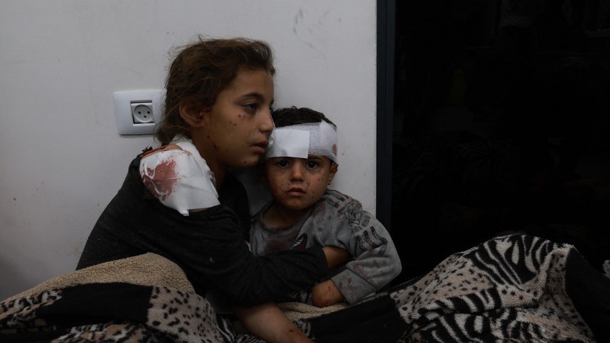 Wounded Palestinian girl Somay al-Najar comforts her brother Yamen following Israeli bombardments over Rafah in the southern Gaza Strip on 12 February, 2024 (AFP)