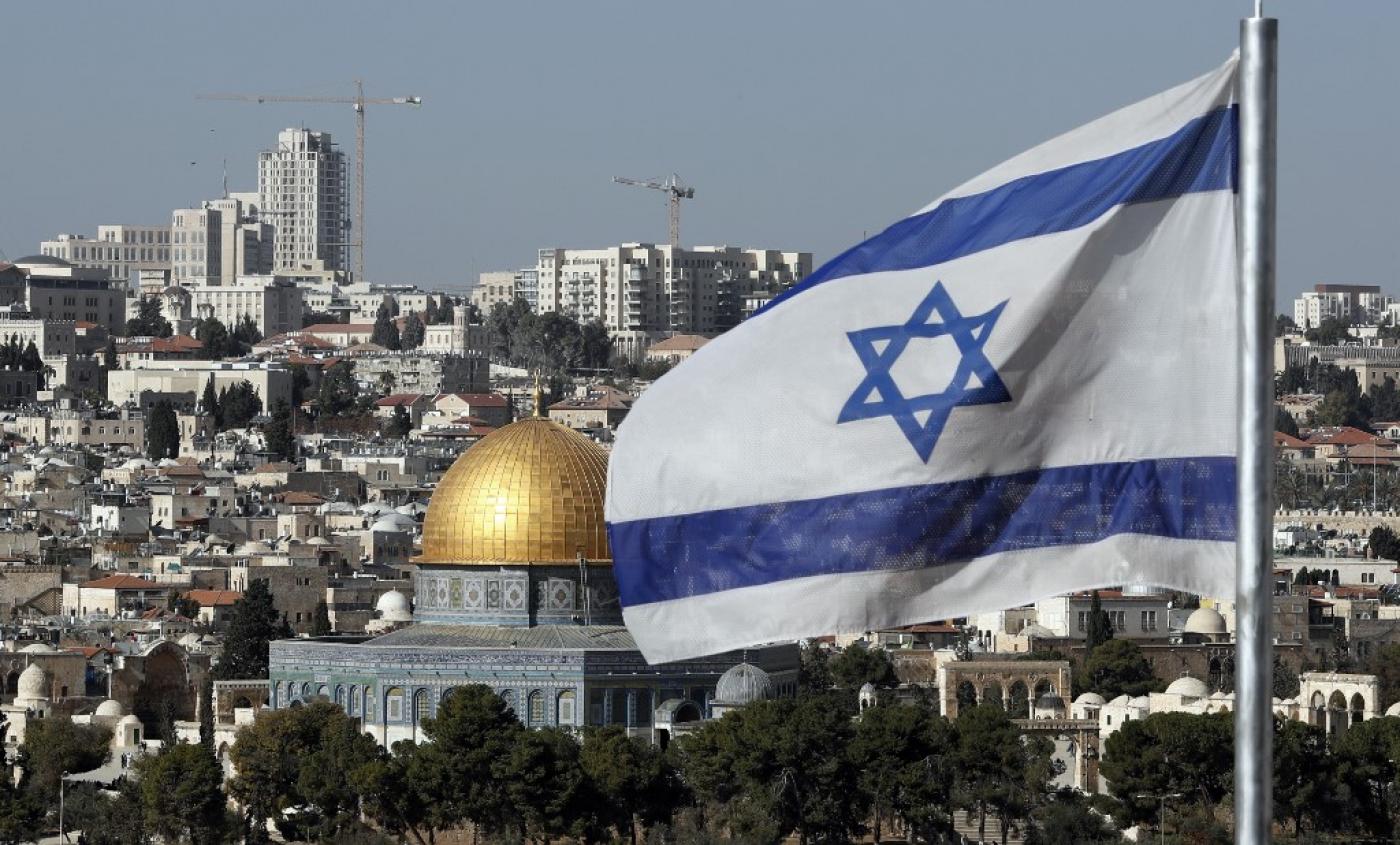 An Israeli flag flies in front of the Old City of Jerusalem in 2017 (AFP)