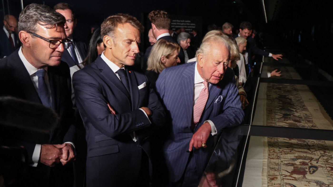 From left: UK PM Andy Burnham, French President Emmanuel Macron and King Charles examine the Bayeux Tapestry at the British Museum, London, on 2 September 2026 (AFP)