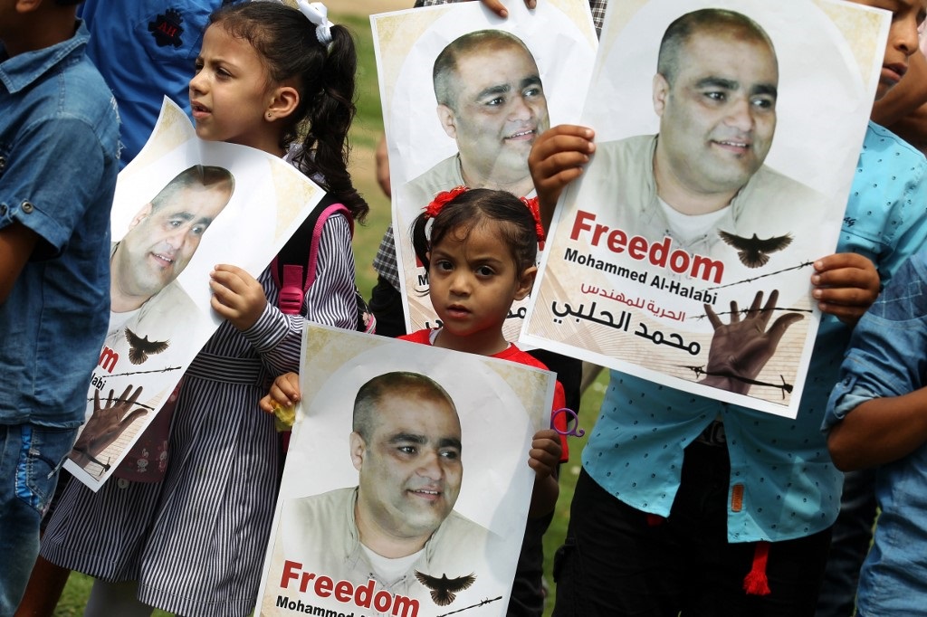 Palestinian children hold posters of al-Halabi during a protest to support him in Rafah in August 2016 (AFP)