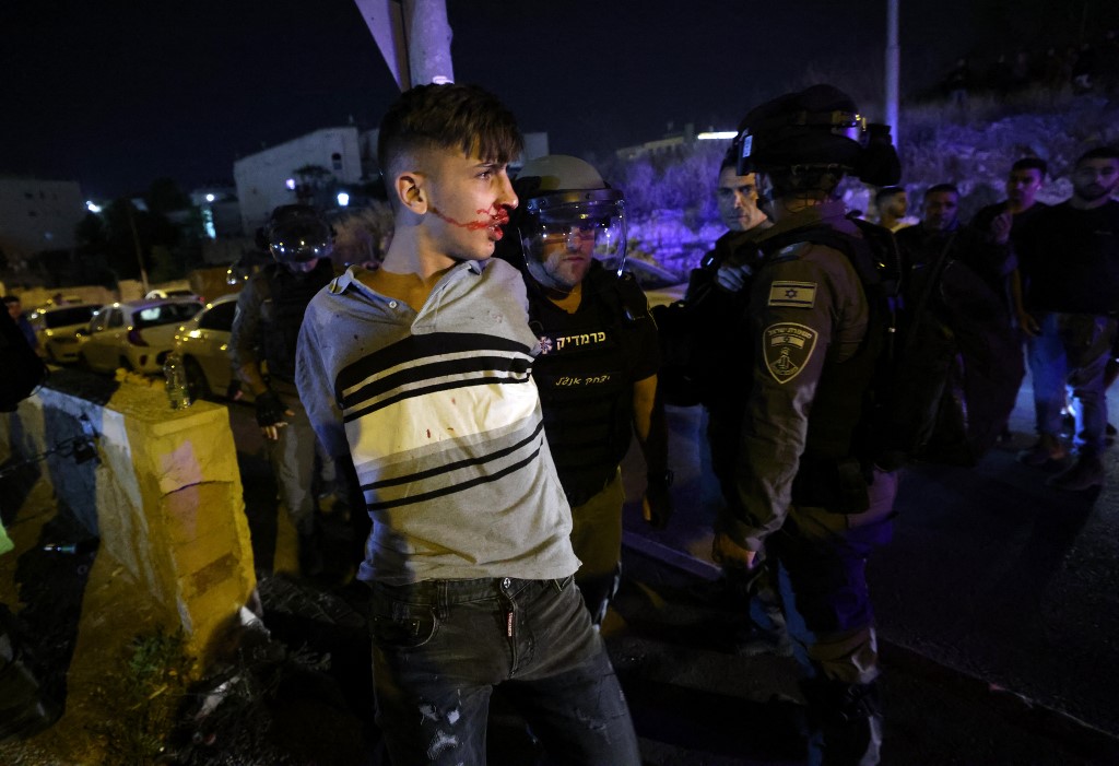 A Palestinian youth is injured and arrested by Israeli forces during protests in Sheikh Jarrah on 5 May (AFP)