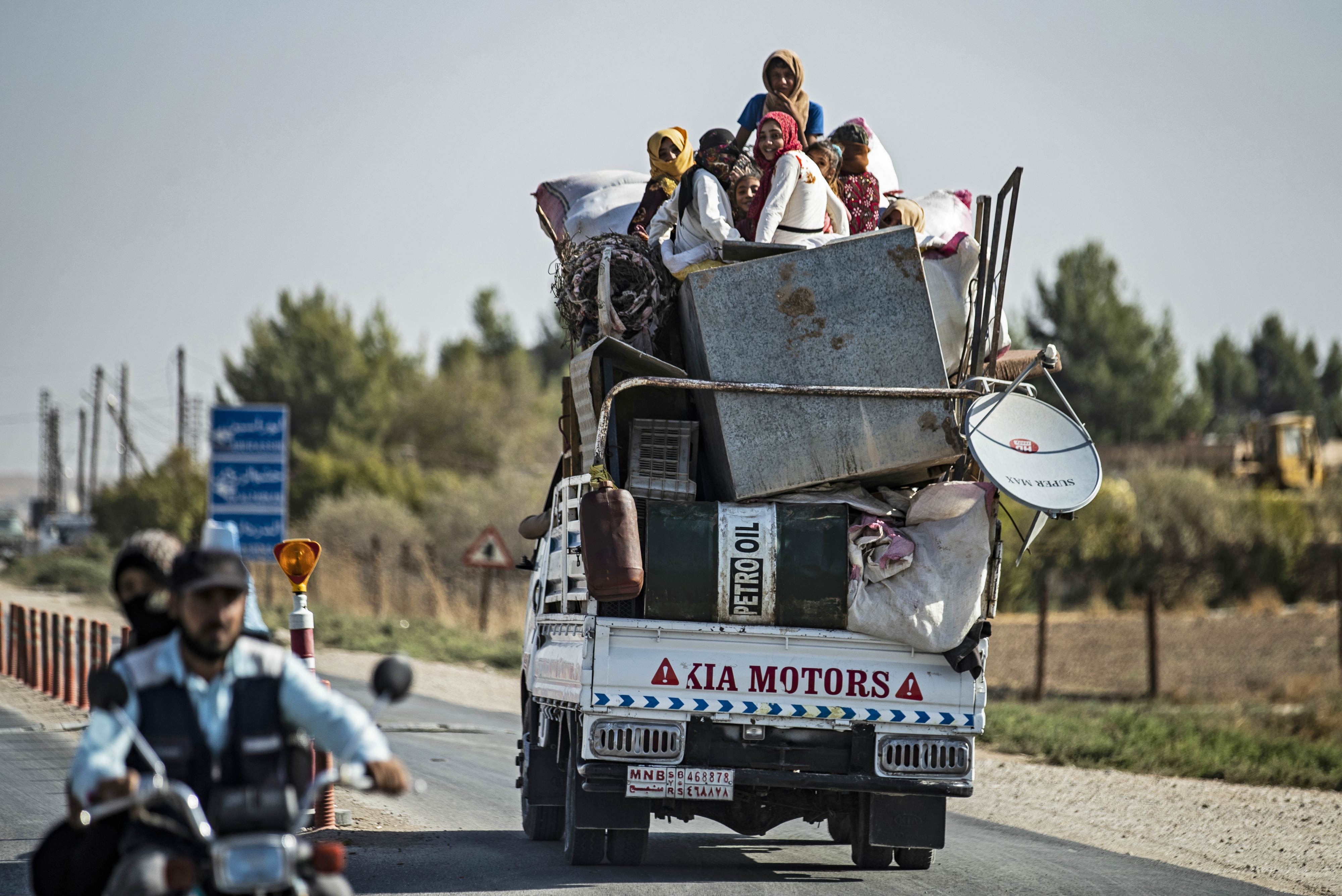 Civilians arrive at Tall Tamr town in Hasakeh province after fleeing the Turkish bombardment (AFP)