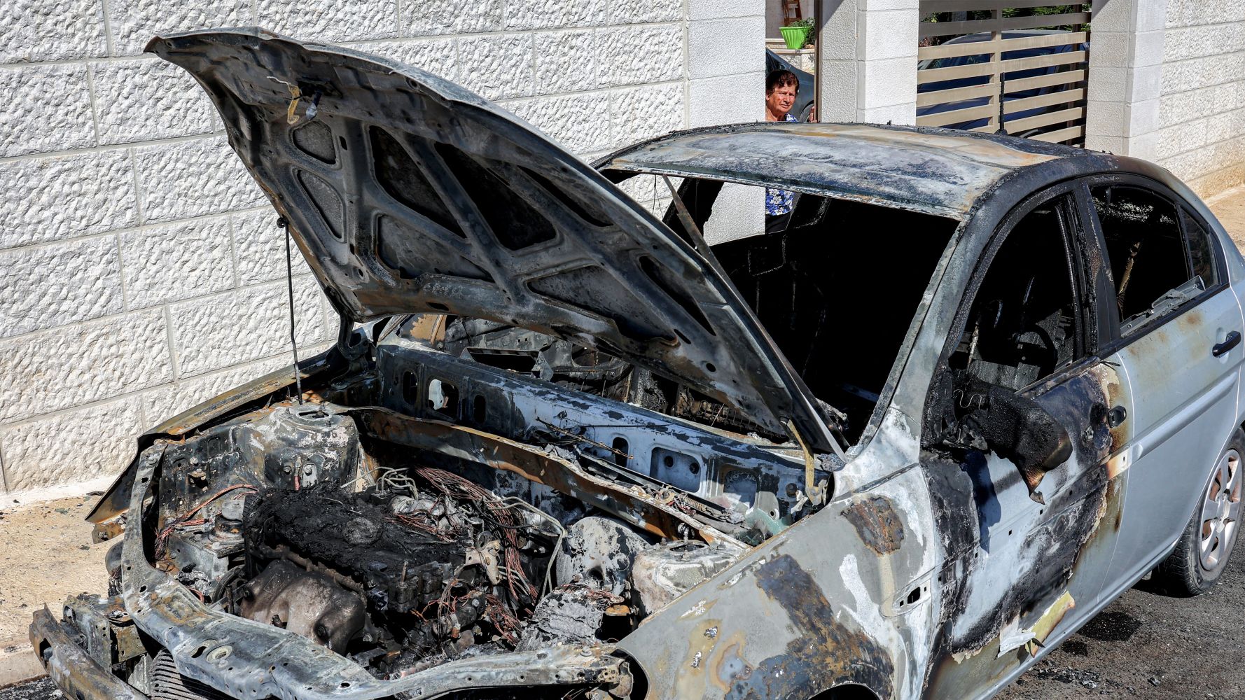 The remains of a car set alight by Israeli settlers in Taybeh on 28 July (AFP/Zain Jaafar)