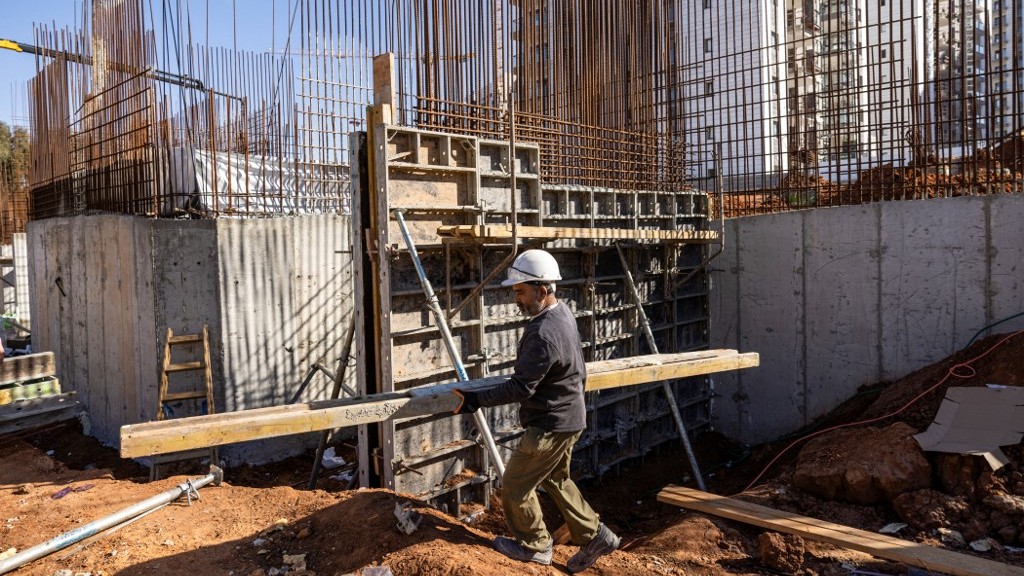 An Indian builder works on a construction site in the Israeli coastal city of Tel Aviv on December 15, 2024. He and other Indian nationals working alongside him are part of an Israeli government effort to fill a void left by tens of thousands of Palestinian construction workers barred from entering Israel since Hamas's unprecedented October 7, 2023 attack. Menahem KAHANA / AFP