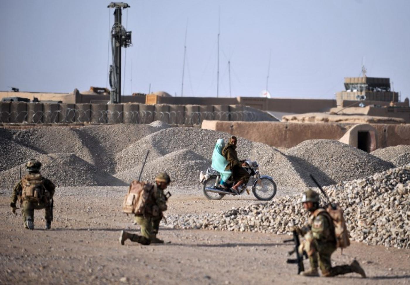Un couple afghan passe devant des soldats du 1er&nbsp;bataillon de The Rifles en patrouille à Nahr-e Saraj, dans la province de Helmand, en juin 2010 (AFP)