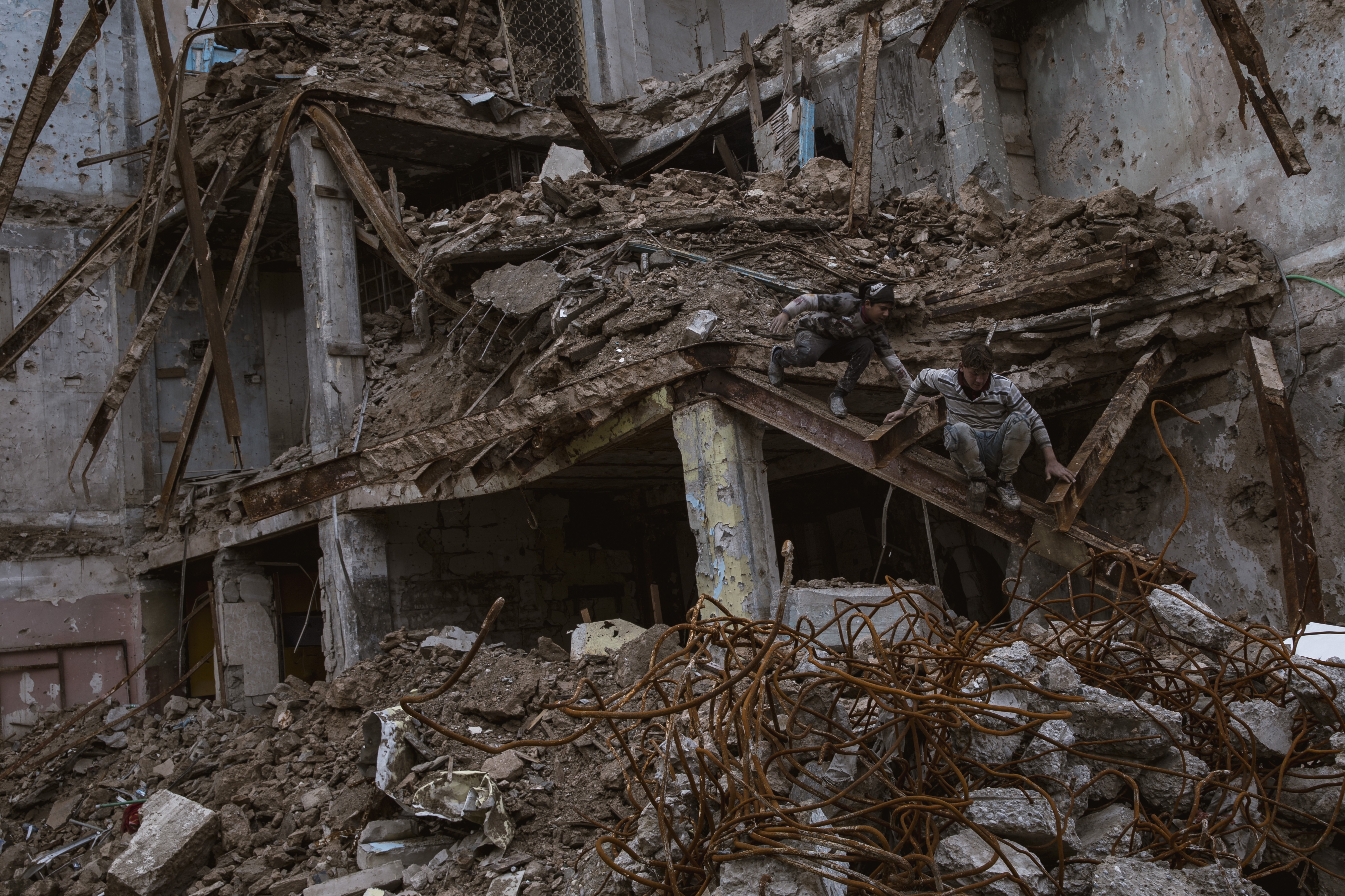 Children collect scraps from destroyed buildings in Mosul's Old City (Tom Westcott/MEE)