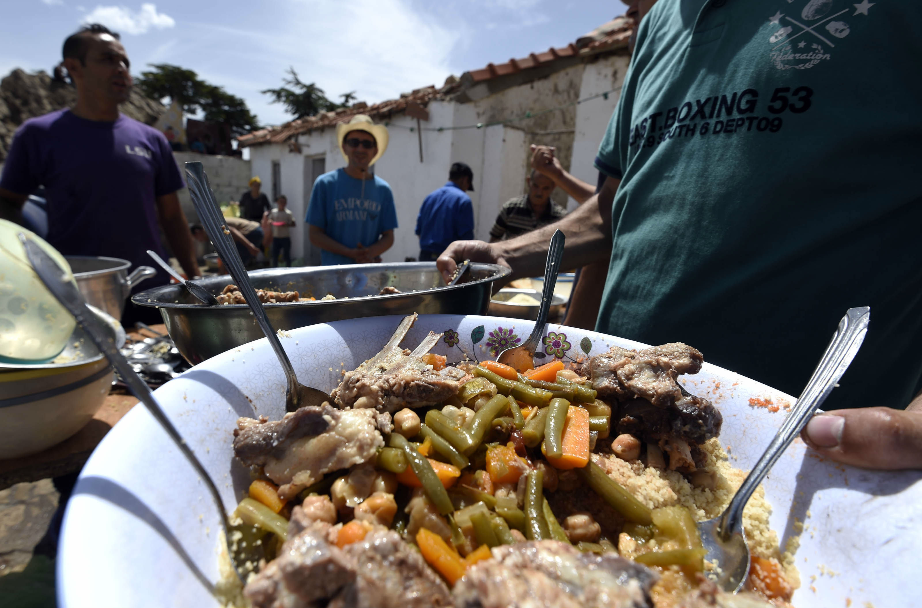 Pilgrims share a plate of couscous after visiting el-Jammaa Oufella in the Djurdjura mountain range, Algeria in 2015 (AFP)