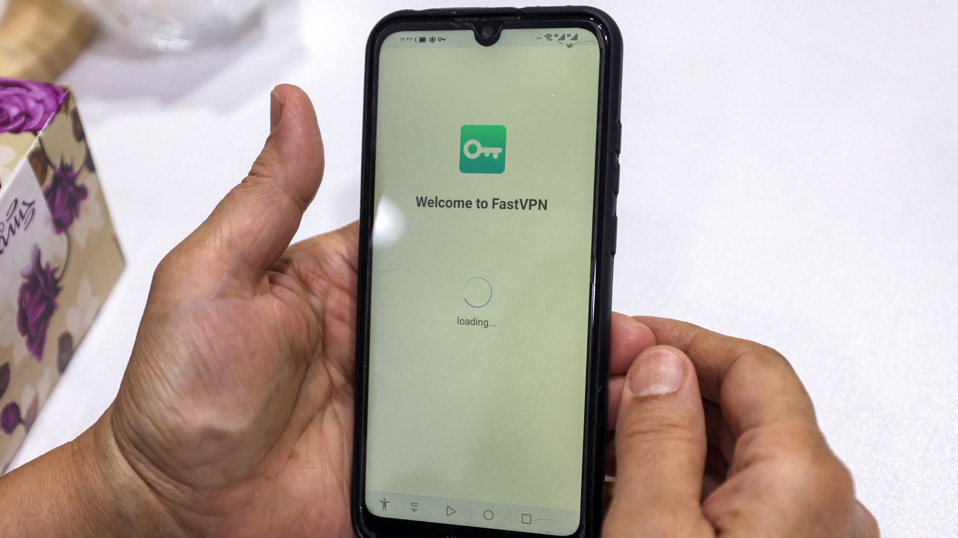 A person holds a phone after activating a VPN service to access the internet while in Tehran on 11 September 2023 (Atta Kenare/AFP)