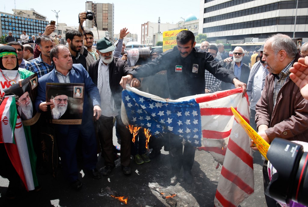Iranian demonstrators burn a makeshift US flag during a rally in Tehran in May 2019 (AFP)