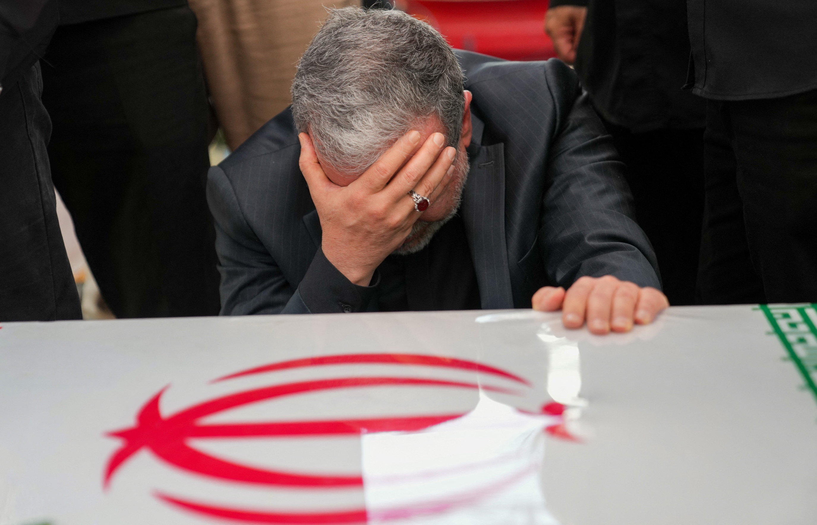 Iran's Foreign Minister Abbas Araghchi mourns next to the coffin of IRGC commander Hossein Salami, during a state funeral procession at Enghelab (Revolution) Square in Tehran on 28 June 2025 (AFP)