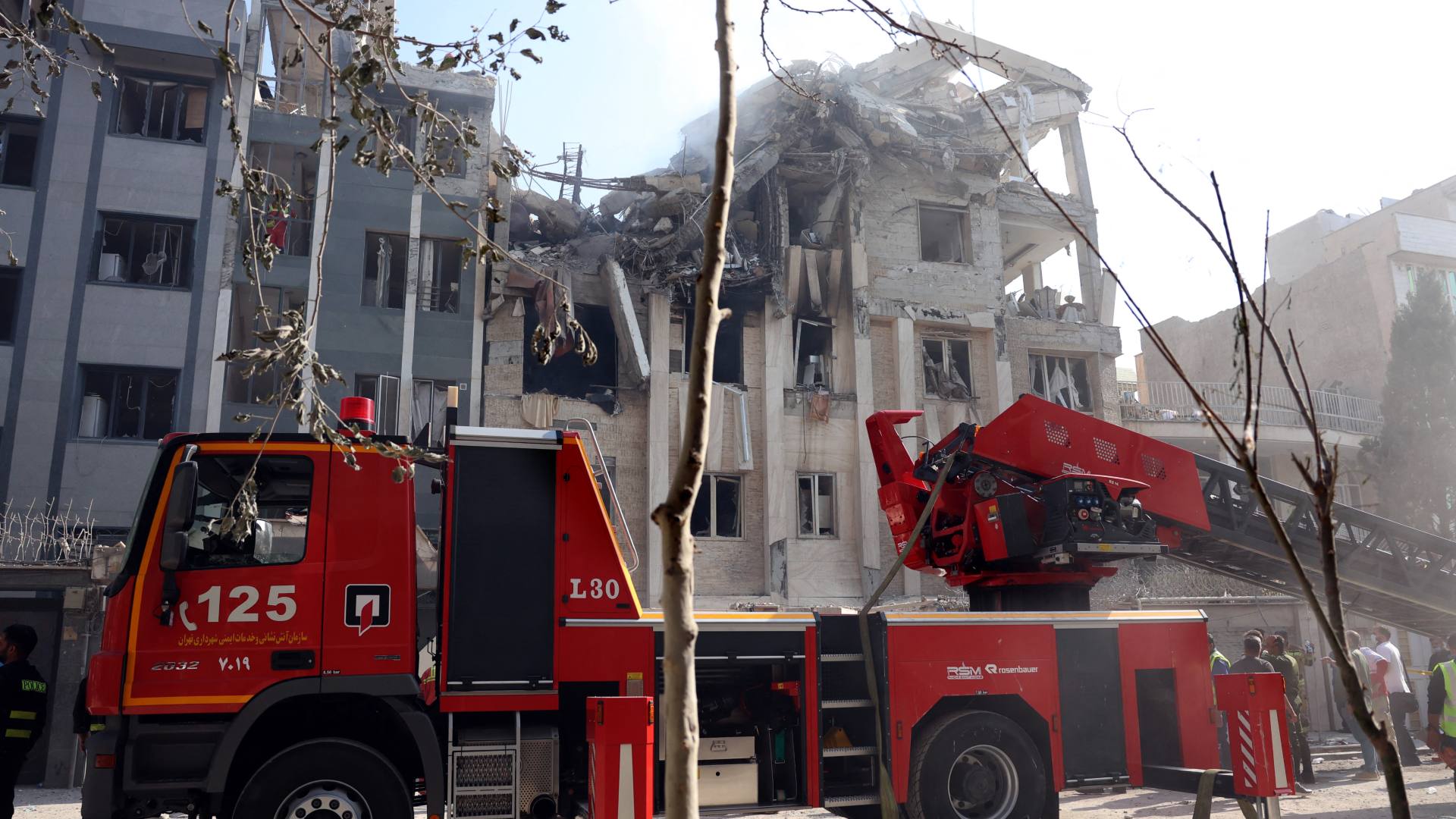Rescue teams in Tehran work outside a heavily damaged building, targeted by an Israeli strike in the Iranian capital on 13 June 2025 (AFP)