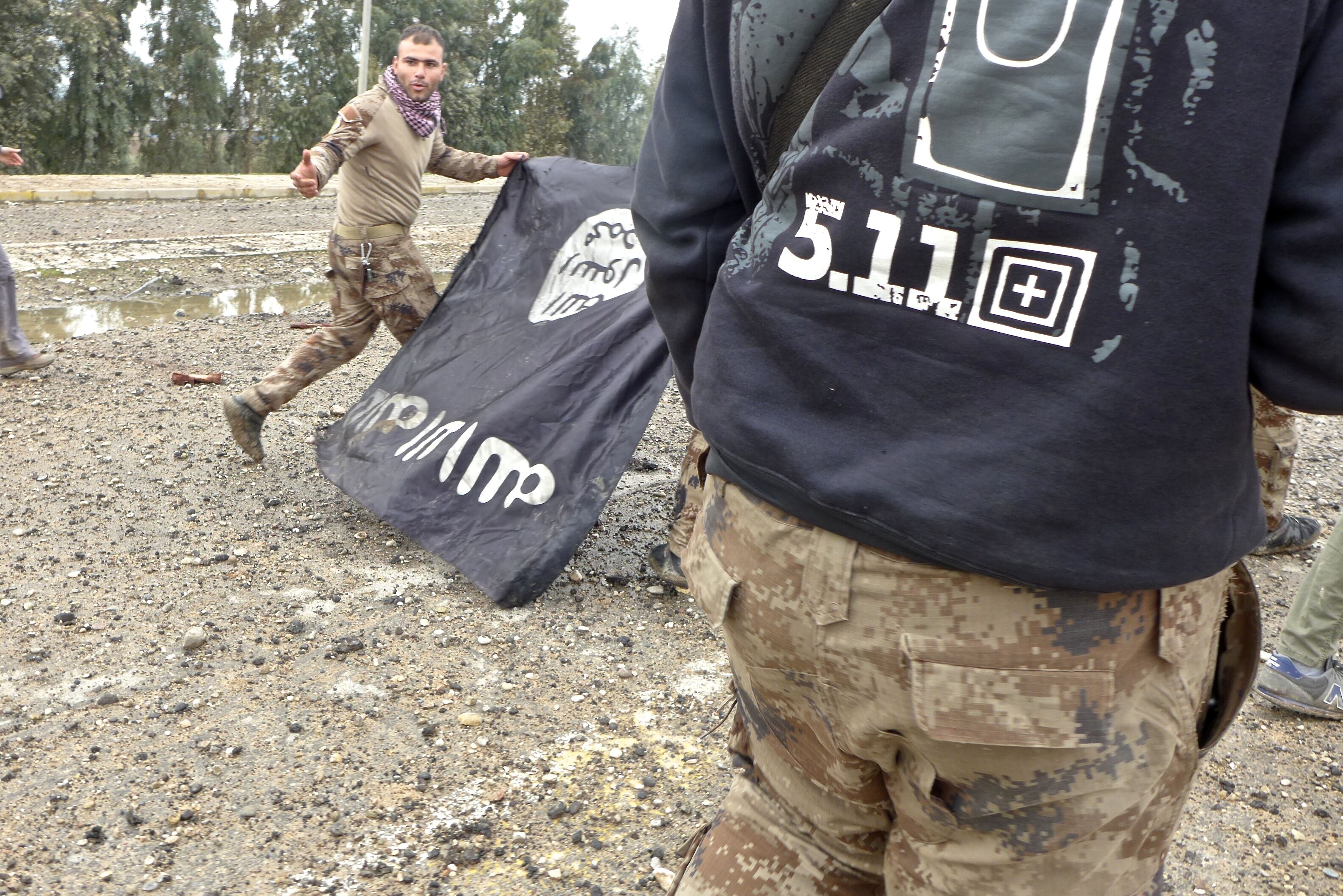 Iraqi Special Forces pull down an IS flag in Mosul in 2017 (MEE/TomWestcott)
