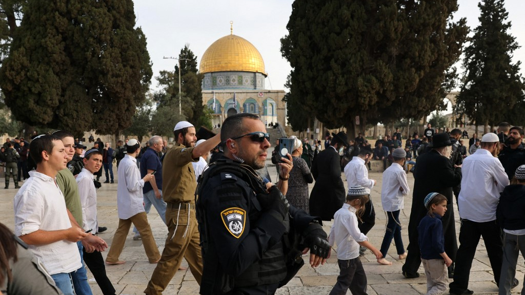 Israeli security forces escort Jewish visitors at Al-Aqsa Mosque complex in Jerusalem on 9 April 2023 (Ahmad Gharabli/AFP)