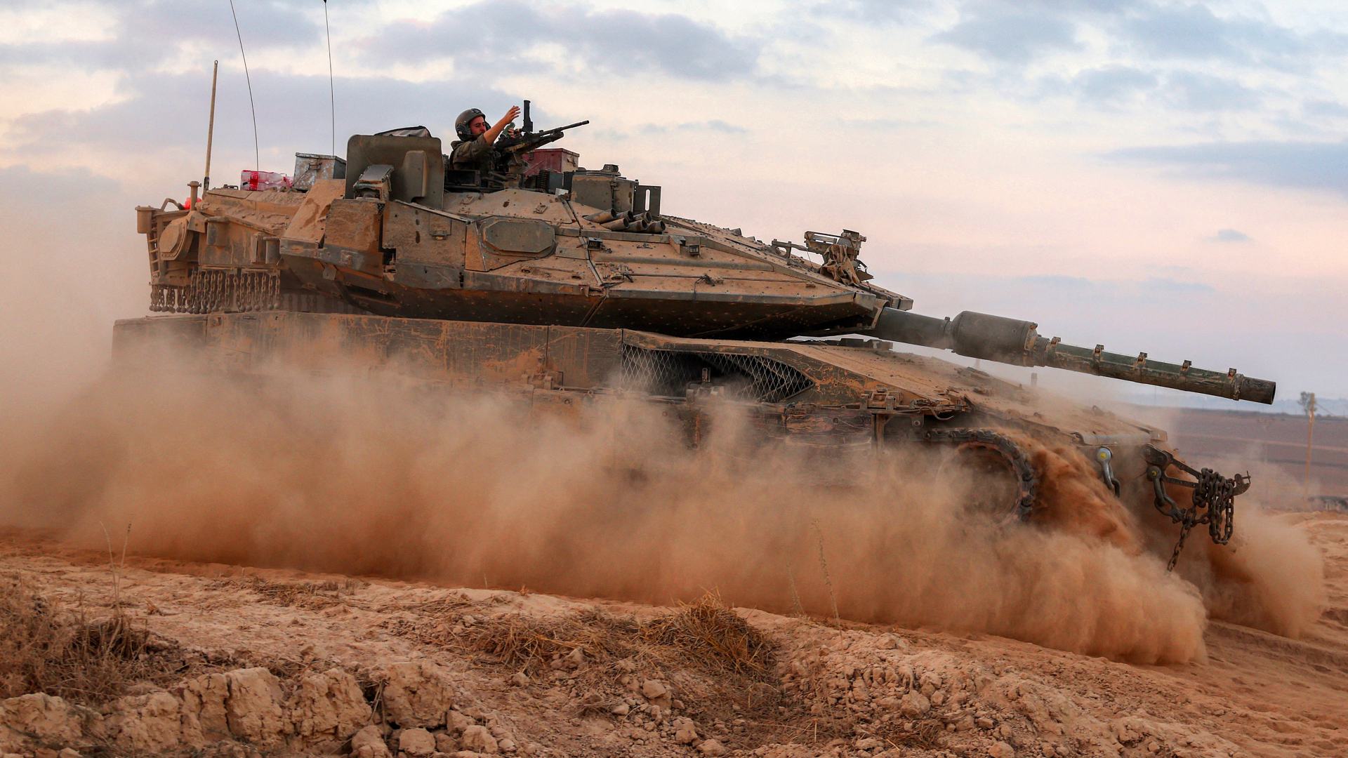 A Merkava tank, pictured here and above, patrols the fence between Israel and Gaza on 12 September 2025. A number of arms companies supply components for the tank (Jack Guez/AFP)