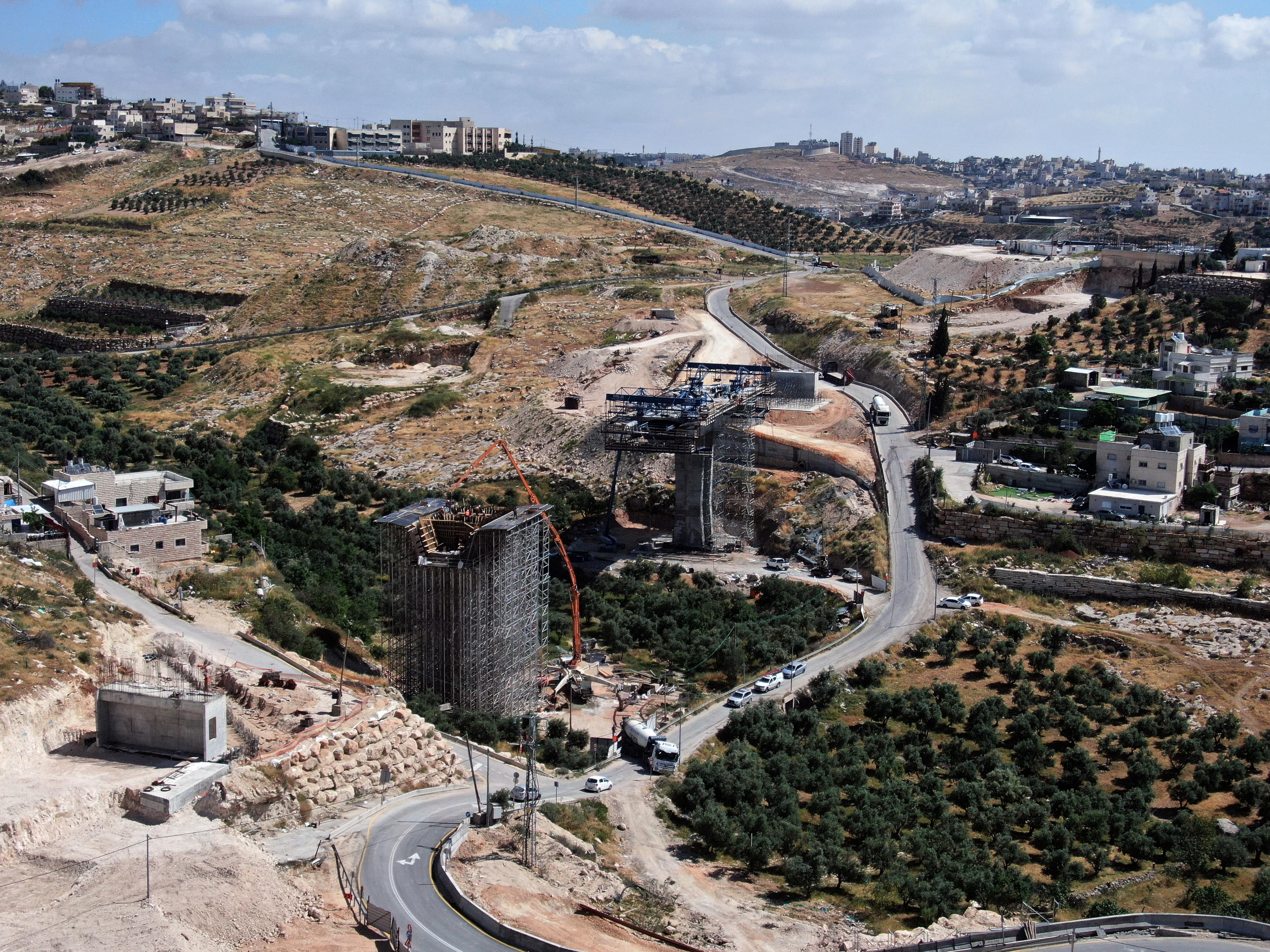 An aerial view shows a bridge under construction as part of The American Road in Sur Baher neighbourhood on 10 May 2020. (Reuters)