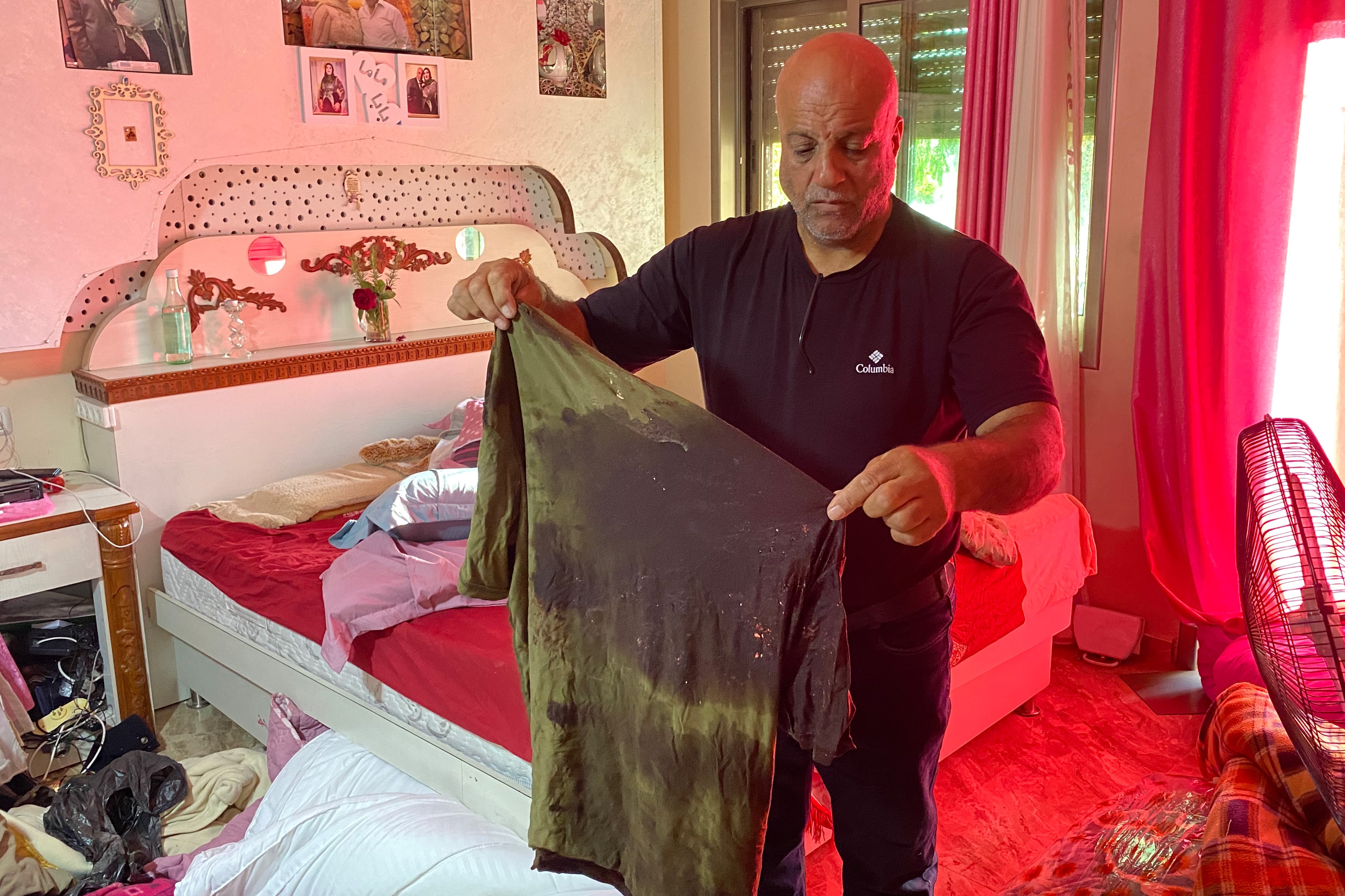 Ibrahim al-Shaham holding the blood-stained shirt of his son Muhammad who was shot dead by Israeli forces on 15 August 2022 in occupied East Jerusalem (MEE/Mohammad Samarin)