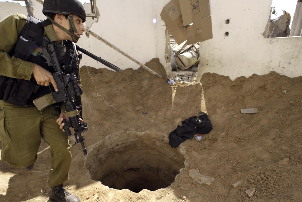 An Israeli soldier walks past the entrance of a large 