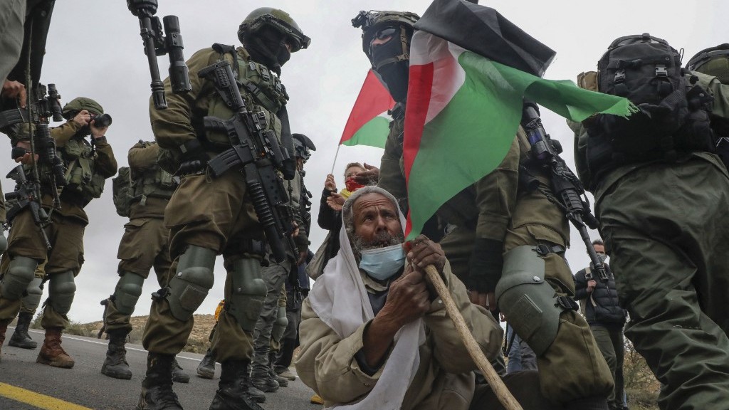 Israeli soldiers arrest a Palestinian man at a demonstration near Yatta village in the occupied West Bank on 15 January 2021 (AFP)